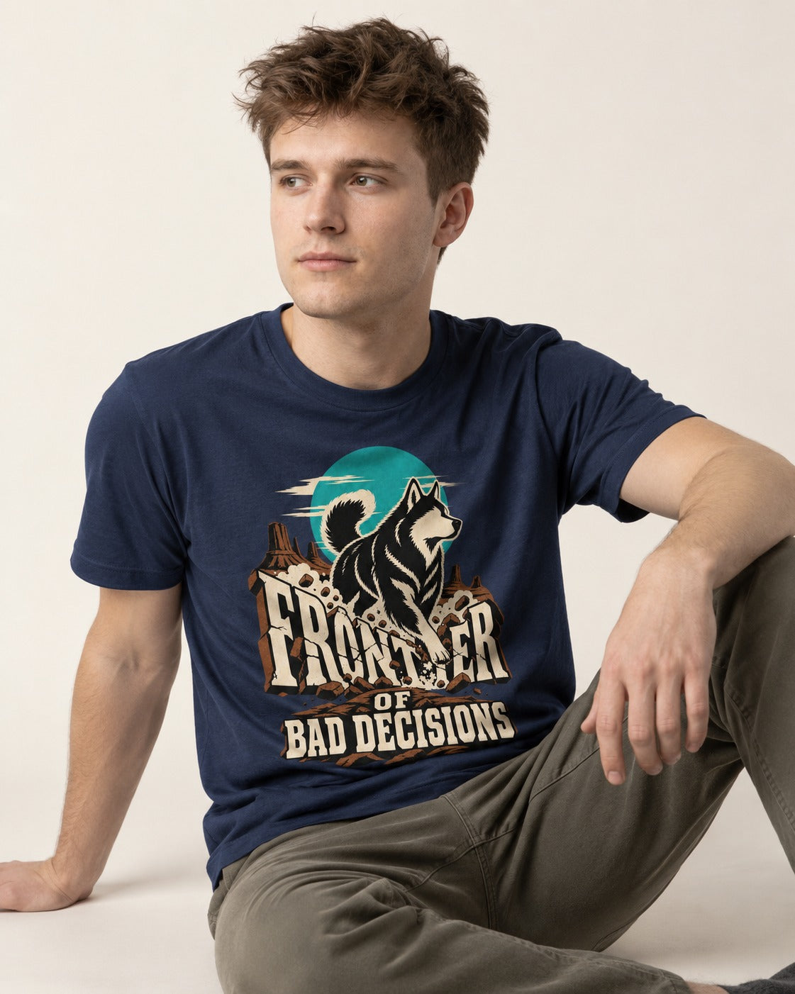 Husky Frontier of Bad Decisions Desert Graphic T-Shirt in Navy, worn by a seated model