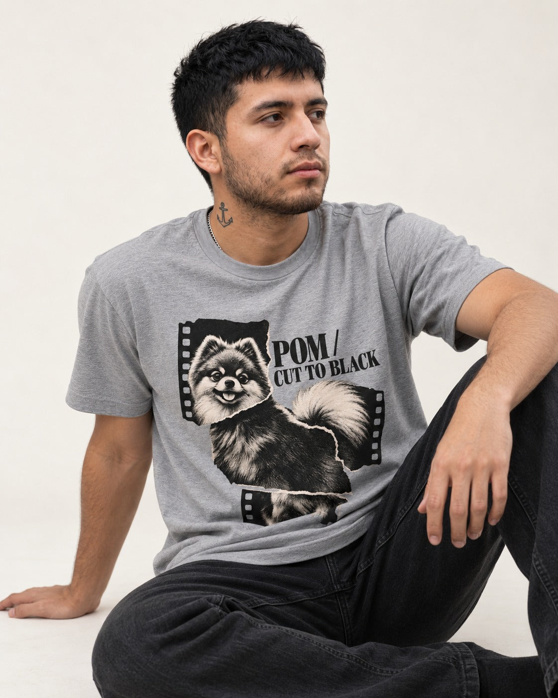 Pomeranian Cut to Black T-Shirt in Sport Grey, worn by a seated model
