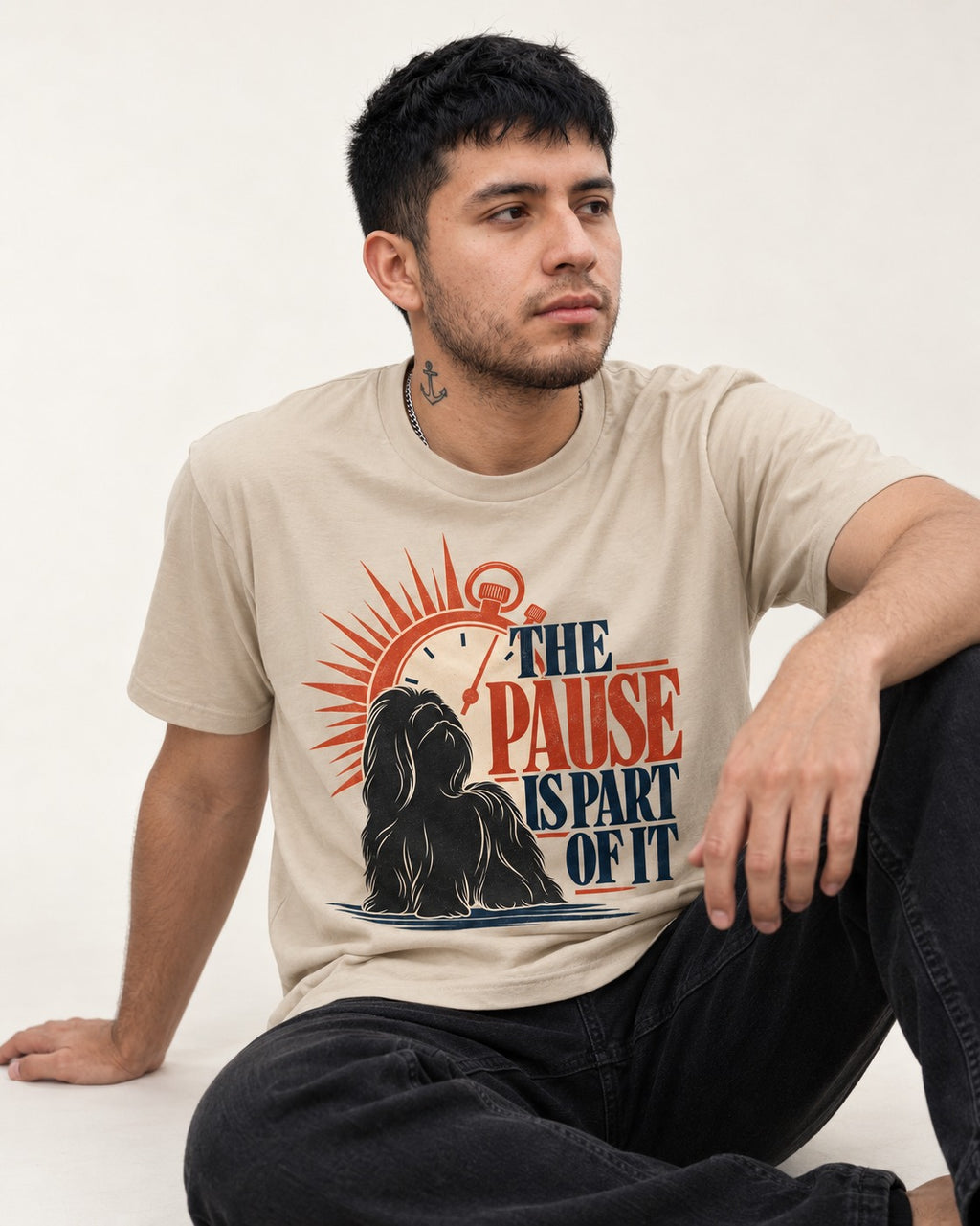 The Shih Tzu Pause T-Shirt in Sand, worn by a seated model