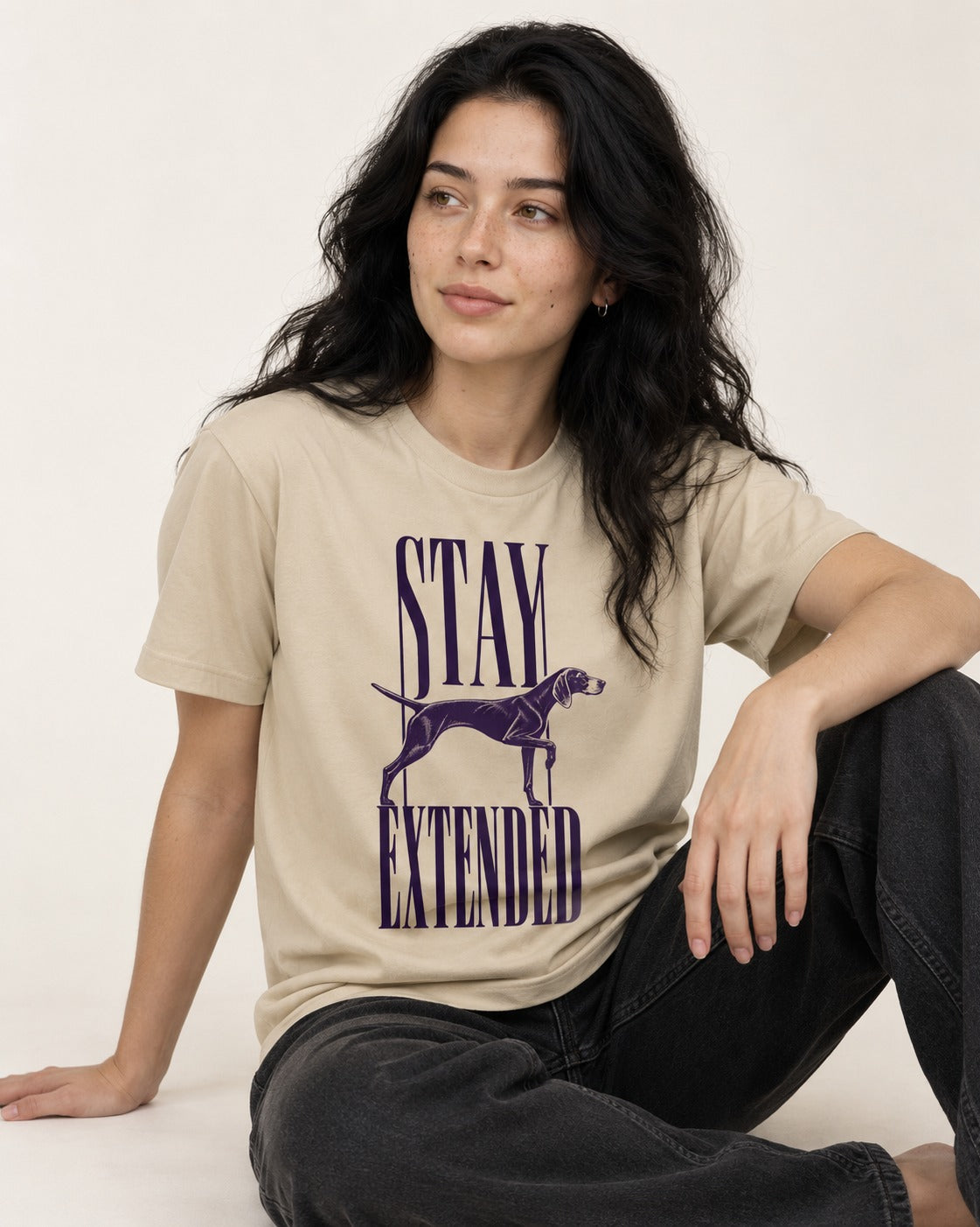 Stay Extended German Shorthaired Pointer T-Shirt in Sand, worn by a seated model