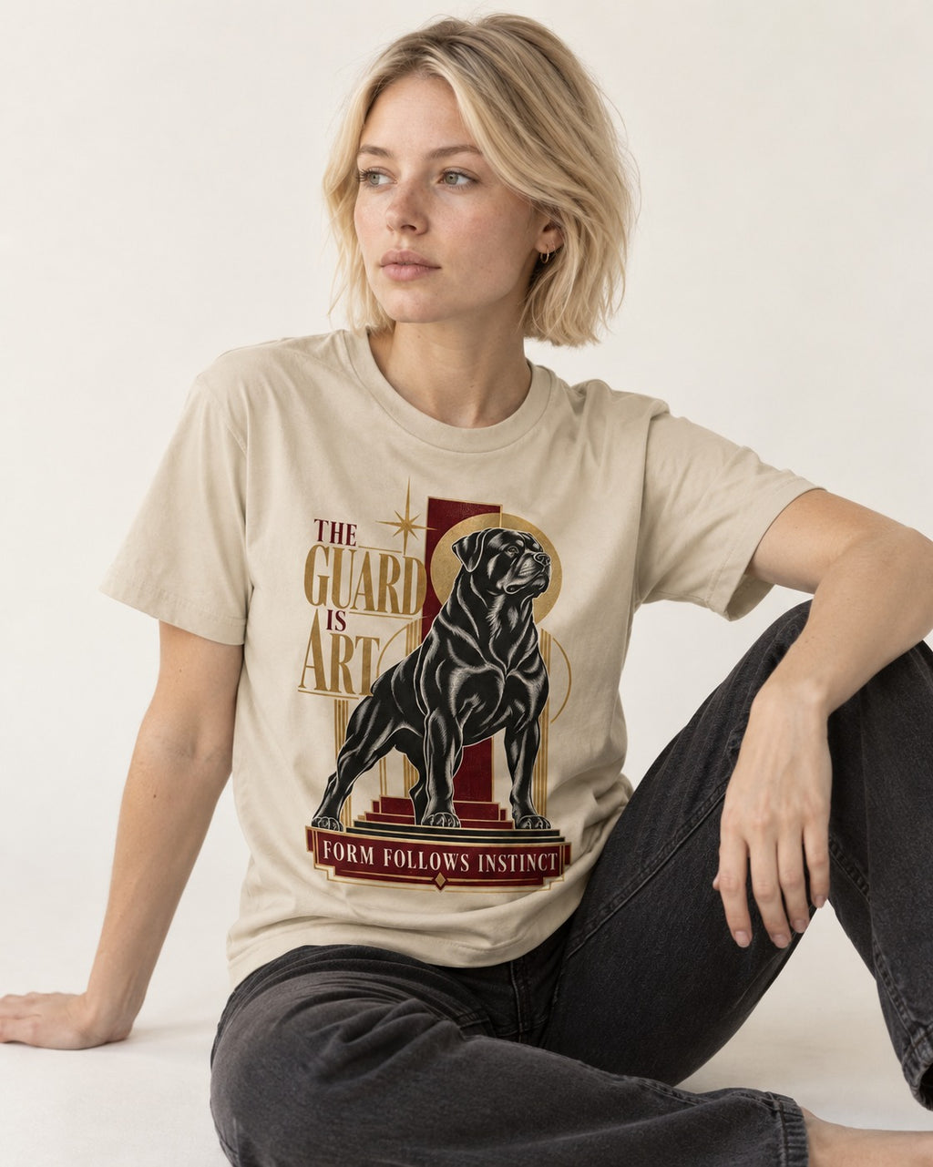 Rottweiler Form Follows Instinct T-Shirt in Sand, worn by a seated model