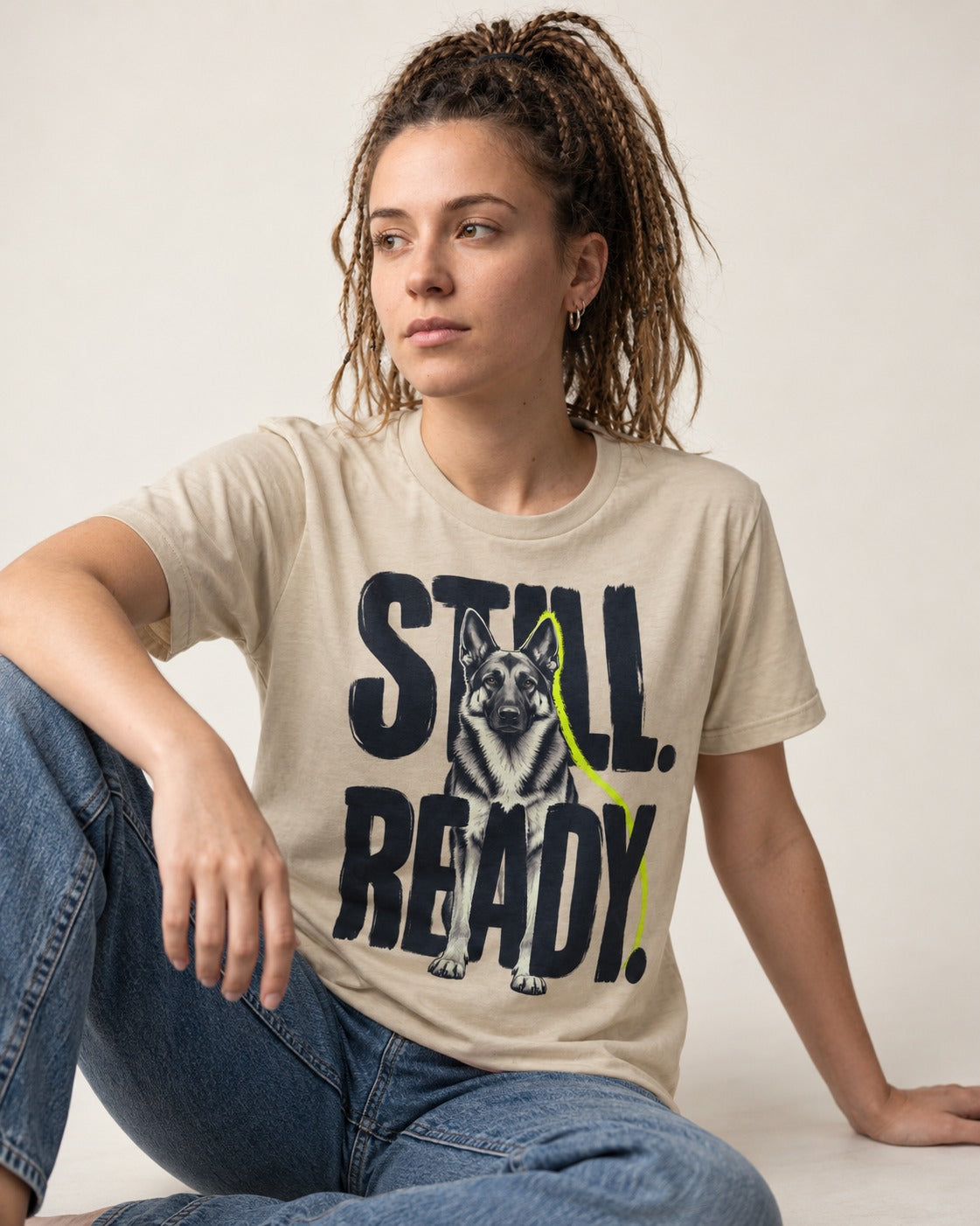 Still Ready German Shepherd Dog T-Shirt in Sand, worn by a seated model