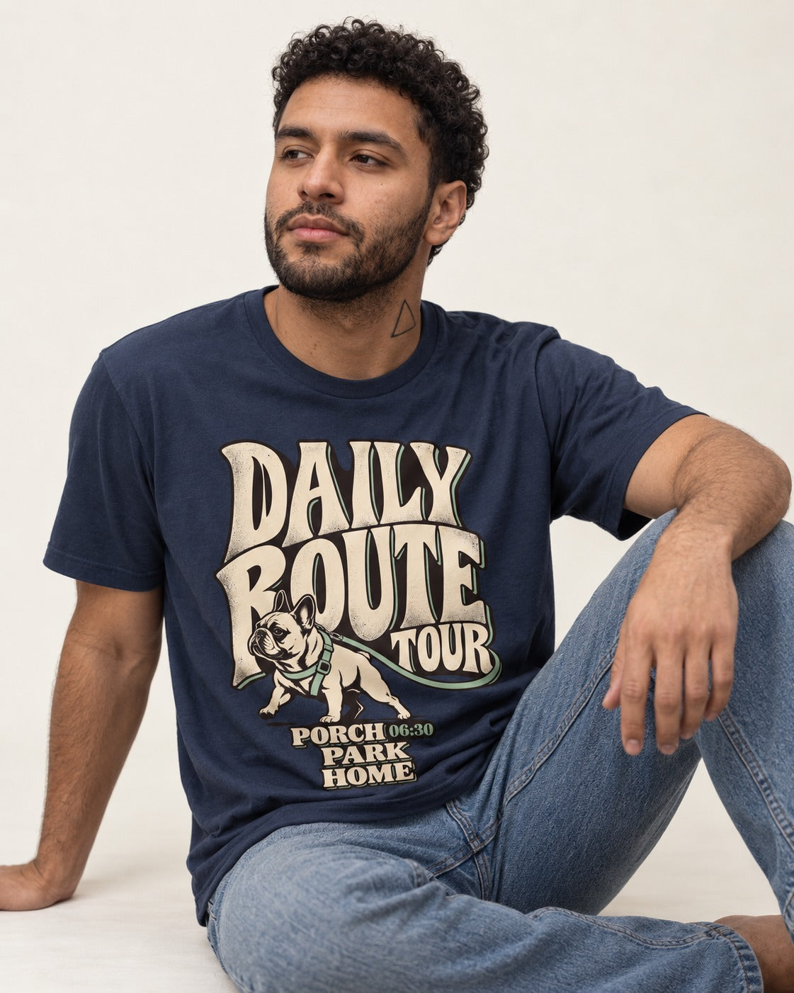 Frenchie Daily Route Tour Graphic T-Shirt in Navy, worn by a seated model
