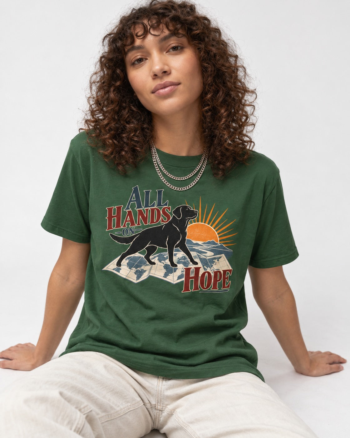 Labrador Retriever All Hands on Hope Map Sunrise Graphic T-Shirt in Forest Green, worn by a seated model