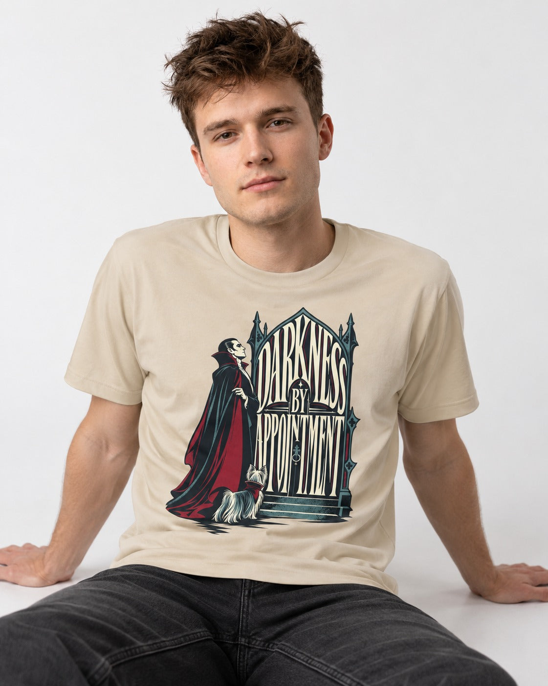 Darkness by Appointment with Yorkshire Terrier T-Shirt in Sand, worn by a seated model