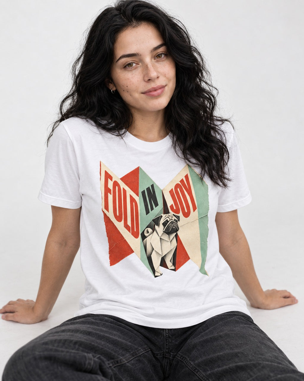 Pug Fold in Joy Geometric Poster Graphic T-Shirt in White, worn by a seated model