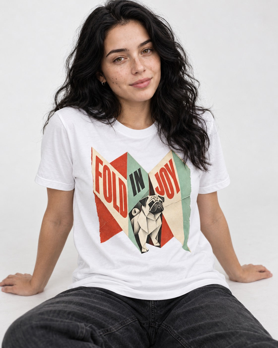 Pug Fold in Joy Geometric Poster Graphic T-Shirt in White, worn by a seated model