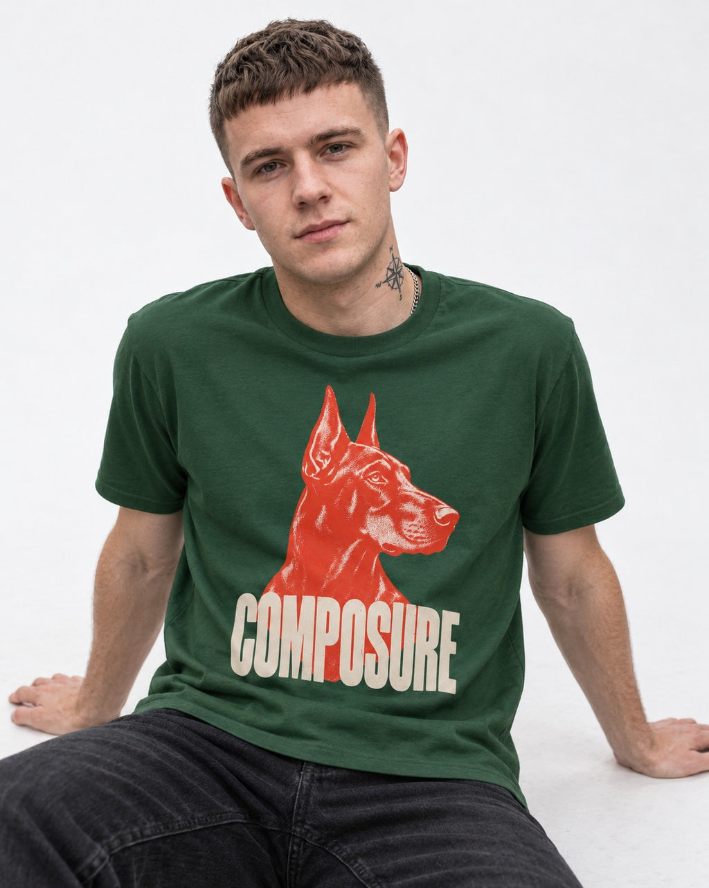 Doberman Composure Portrait Graphic T-Shirt in Forest Green, worn by a seated model
