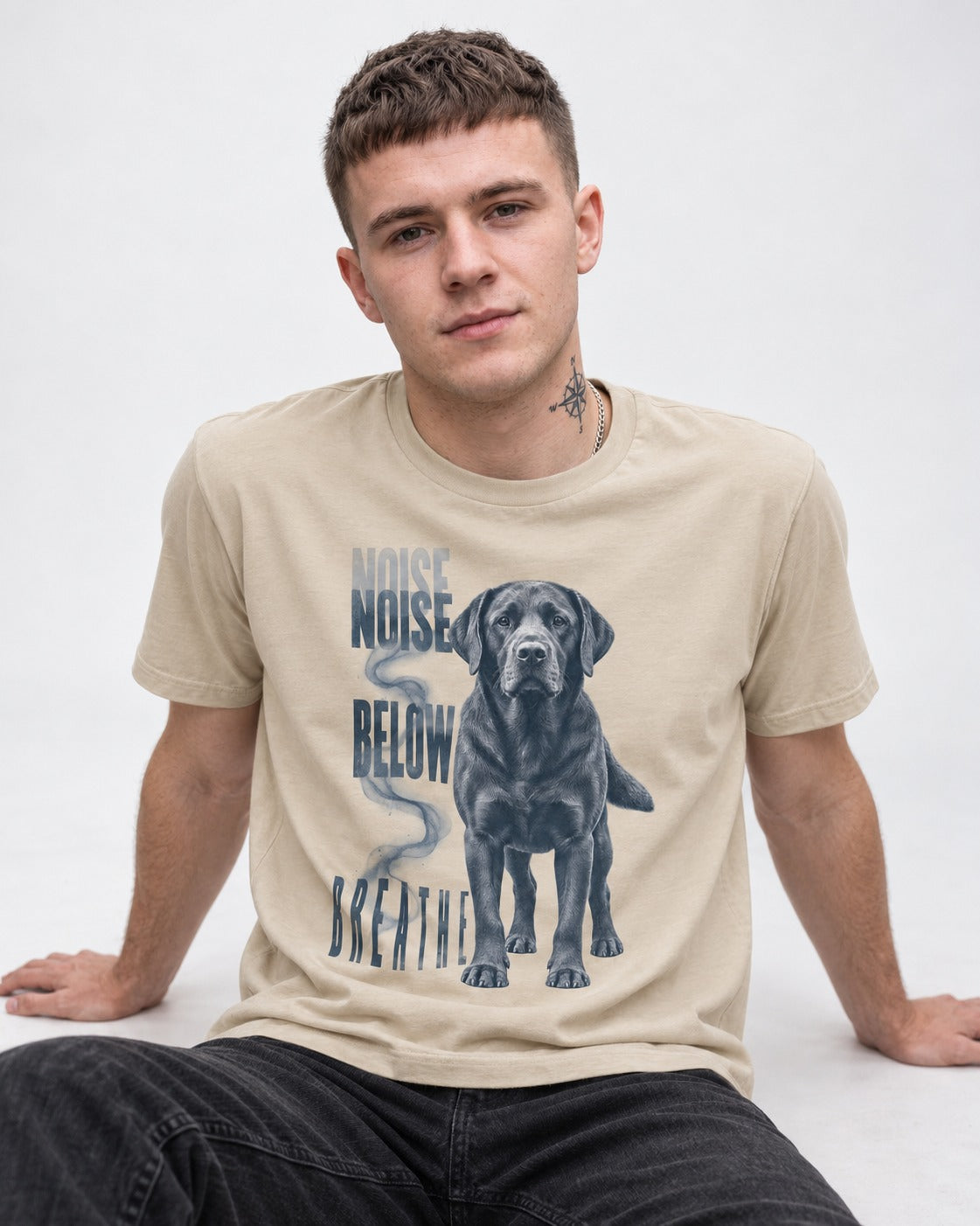 Labrador Retriever Breathe Below the Noise T-Shirt in Sand, worn by a seated model