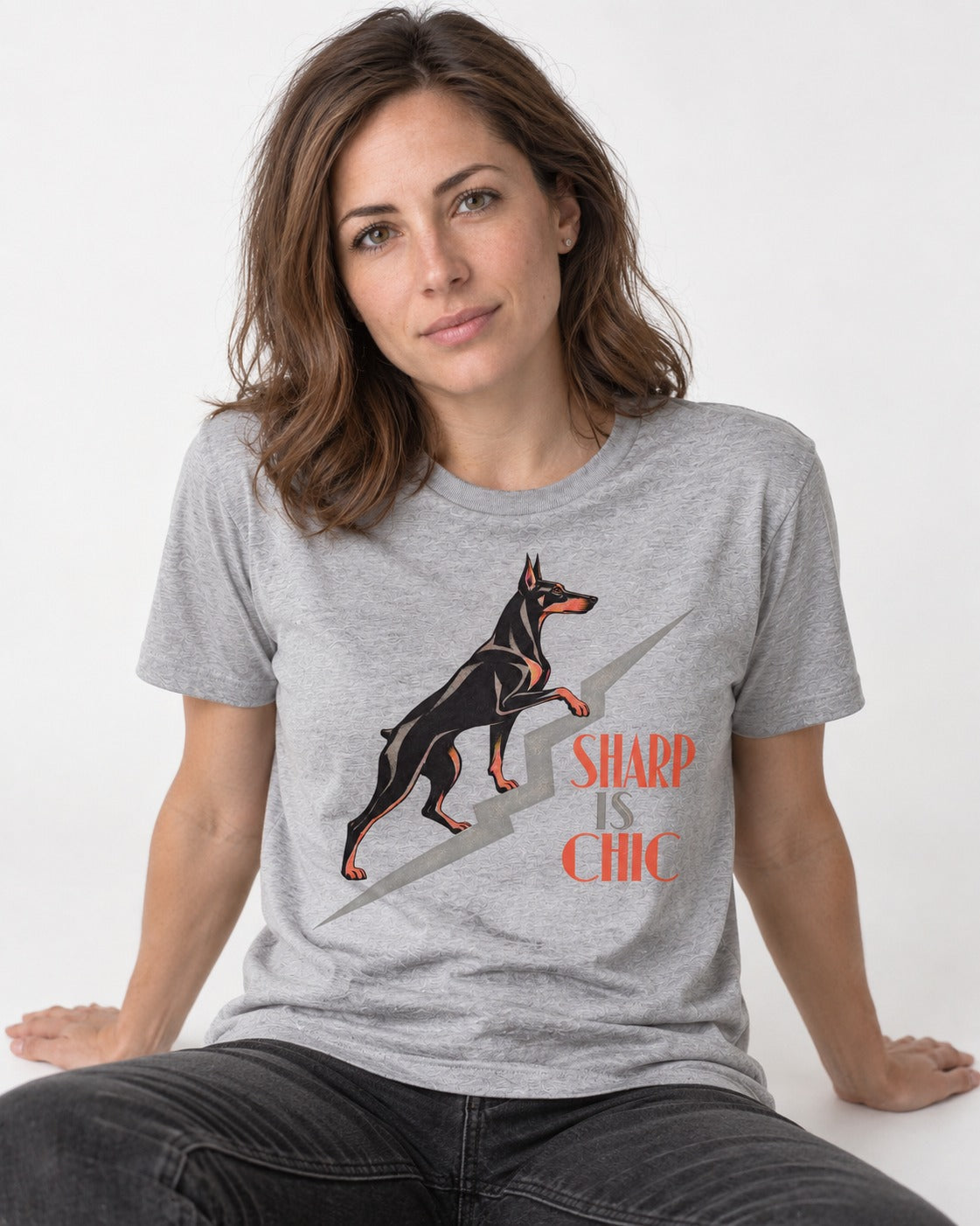 Doberman Is Chic T-Shirt in Sport Grey, worn by a seated model