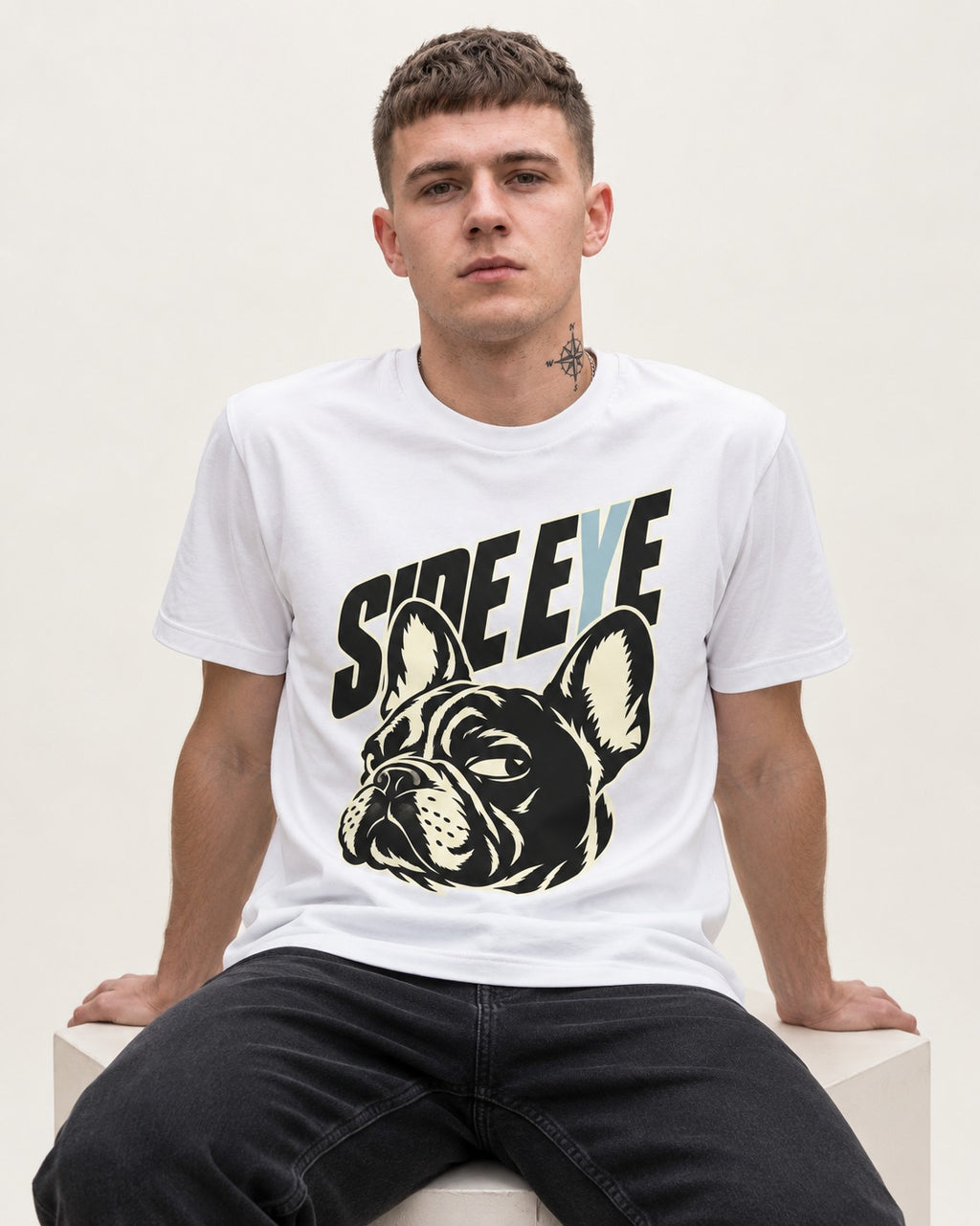 Frenchie Side Eye Portrait Graphic T-Shirt in White, worn by a seated model