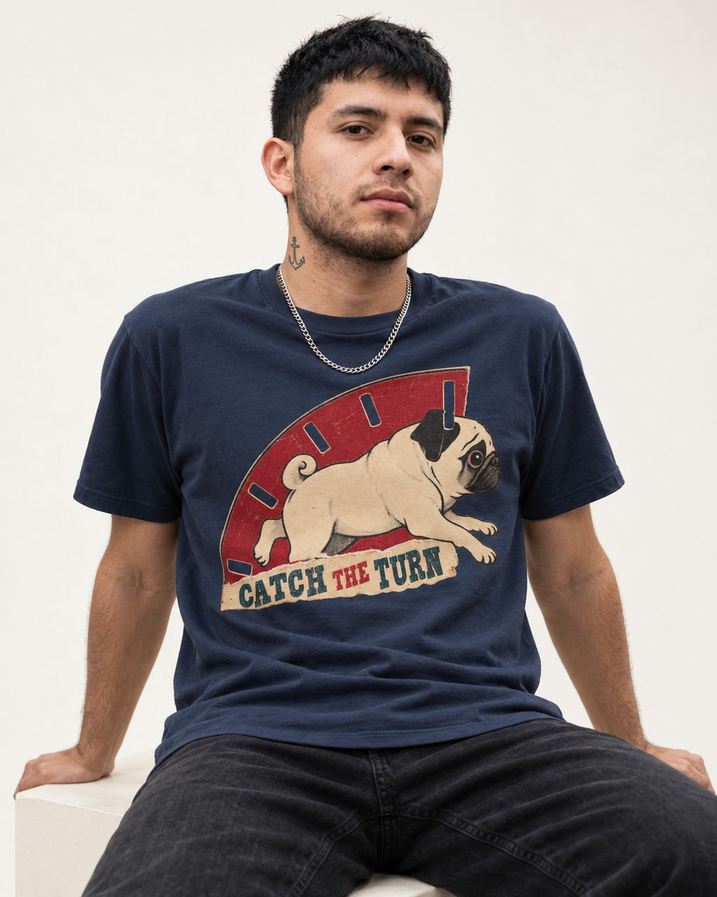Pug Catch the Turn Track Graphic T-Shirt in Navy, worn by a seated model