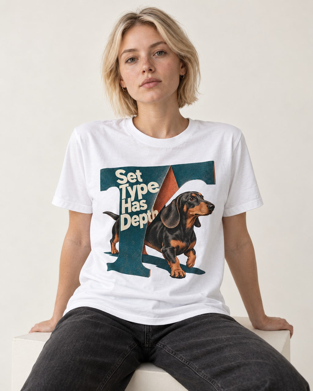 Dachshund Set Type Has Depth Folded Letter Graphic T-Shirt in White, worn by a seated model