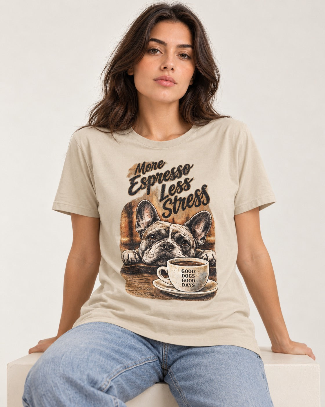 Frenchie More Espresso Less Stress T-Shirt in Sand, worn by a seated model