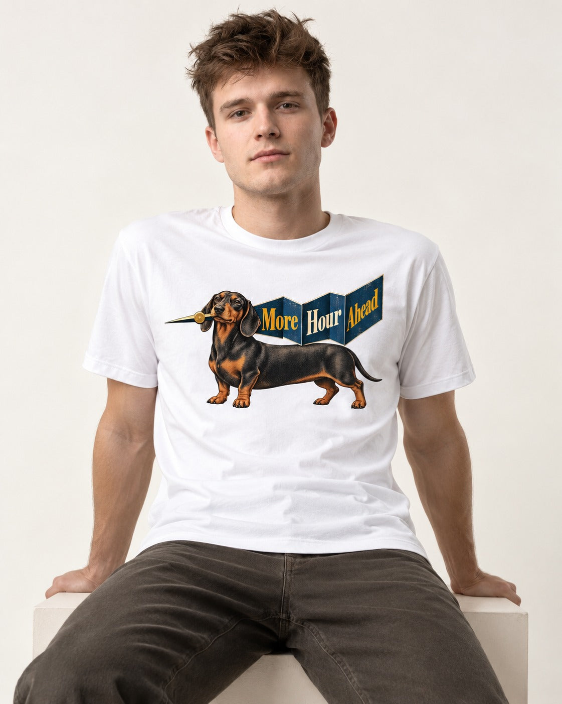 Dachshund More Hour Ahead Foldout Banner Graphic T-Shirt in White, worn by a seated model