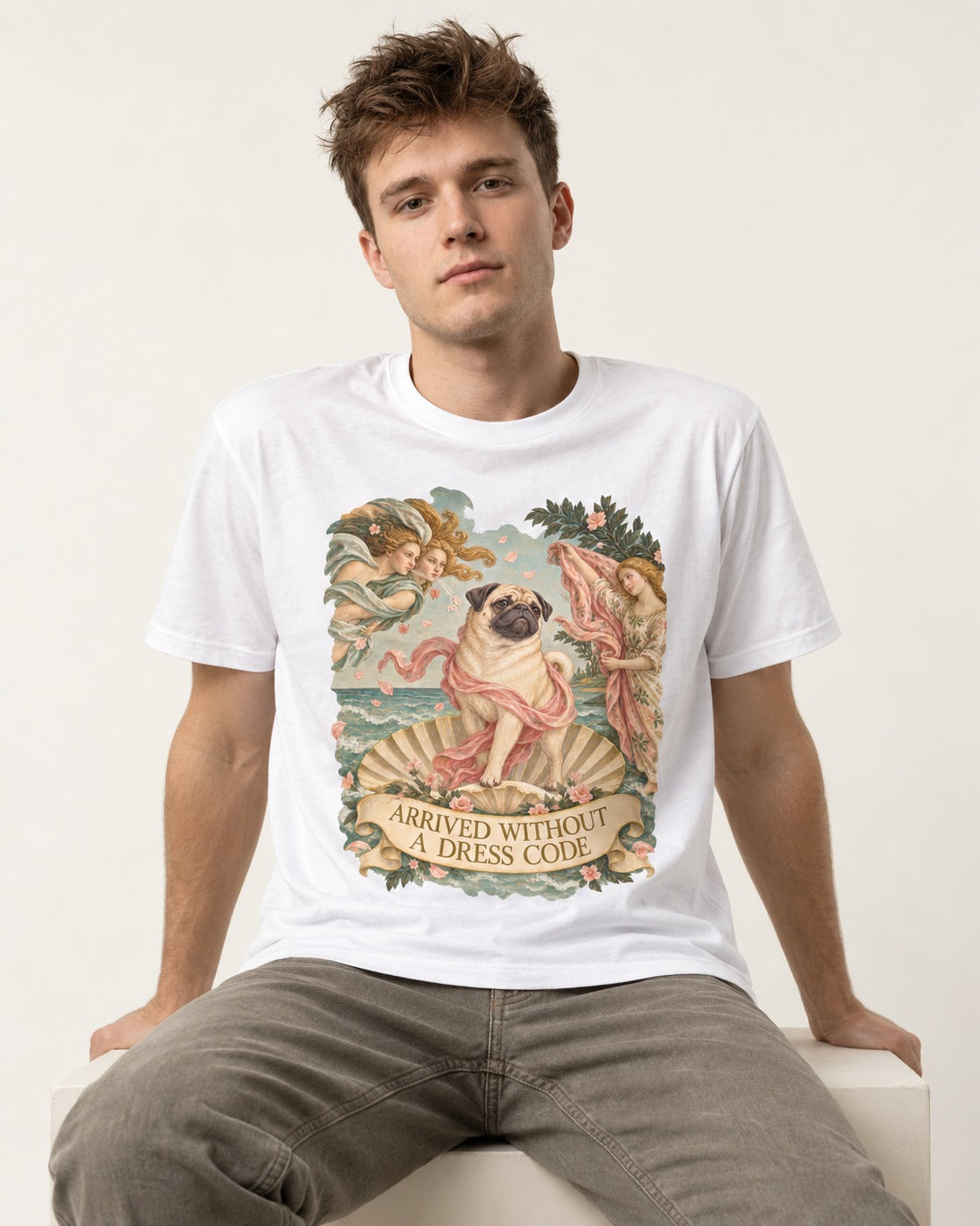 Pug Arrived Without a Dress Code Venus Parody Graphic T-Shirt in White, worn by a seated model