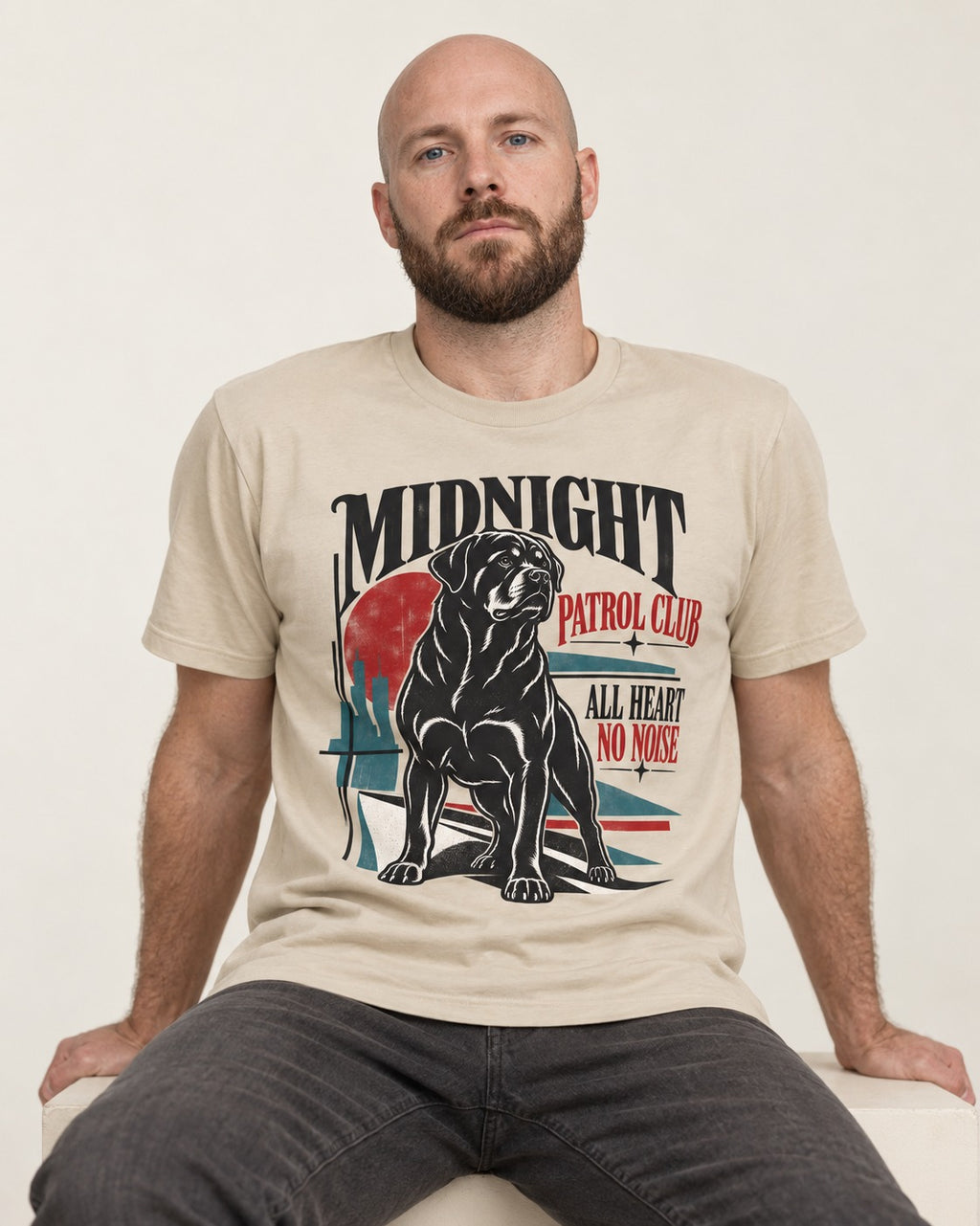 Rottweiler Midnight Patrol Club T-Shirt in Sand, worn by a seated model