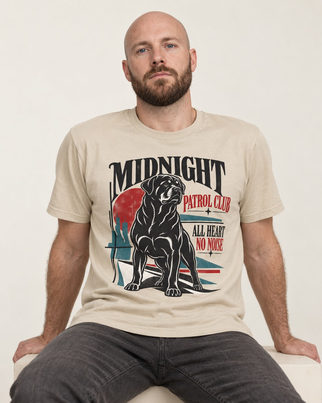 Rottweiler Midnight Patrol Club T-Shirt in Sand, worn by a seated model