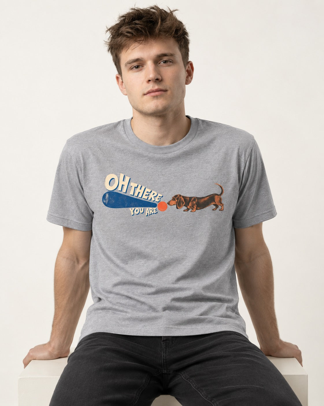 Dachshund Oh There You Are Ball Graphic T-Shirt in Sport Grey, worn by a seated model
