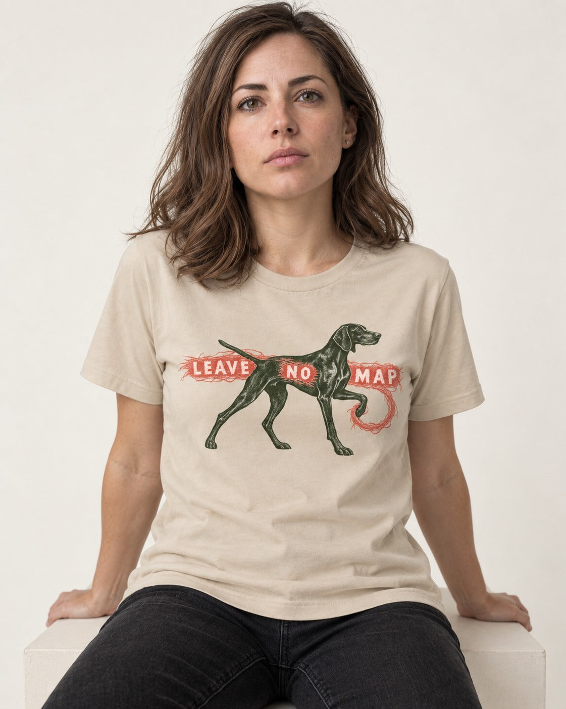 Leave No Map German Shorthaired Pointer T-Shirt in Sand, worn by a seated model