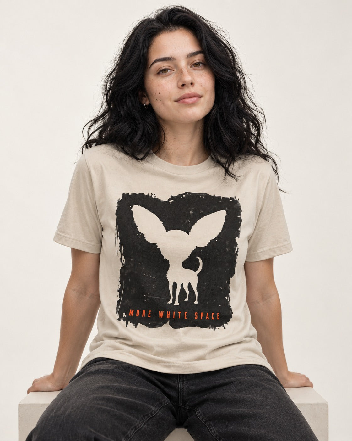 More White Space Chihuahua T-Shirt in Sand, worn by a seated model
