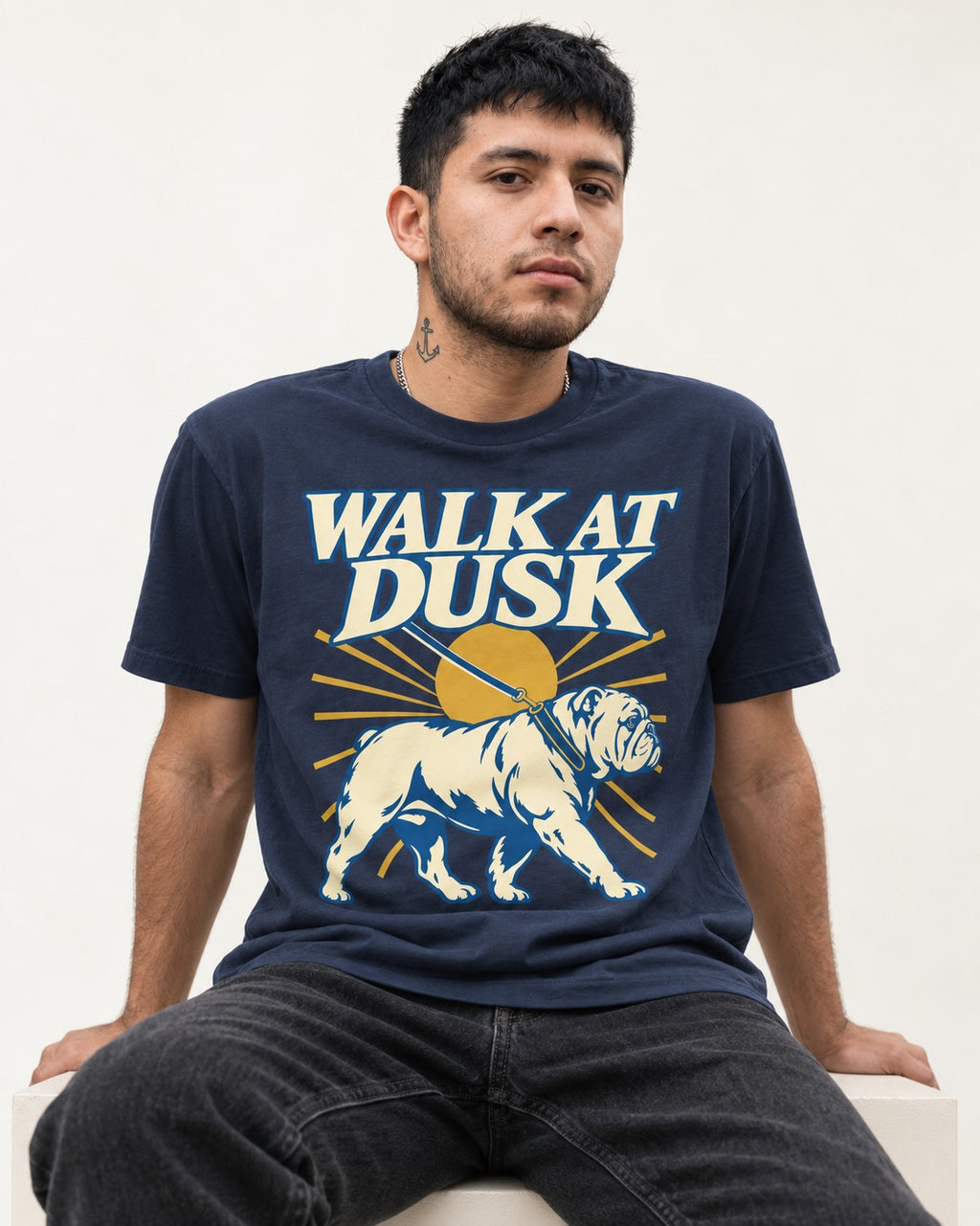 English Bulldog Walk at Dusk Sunset Graphic T-Shirt in Navy, worn by a seated model