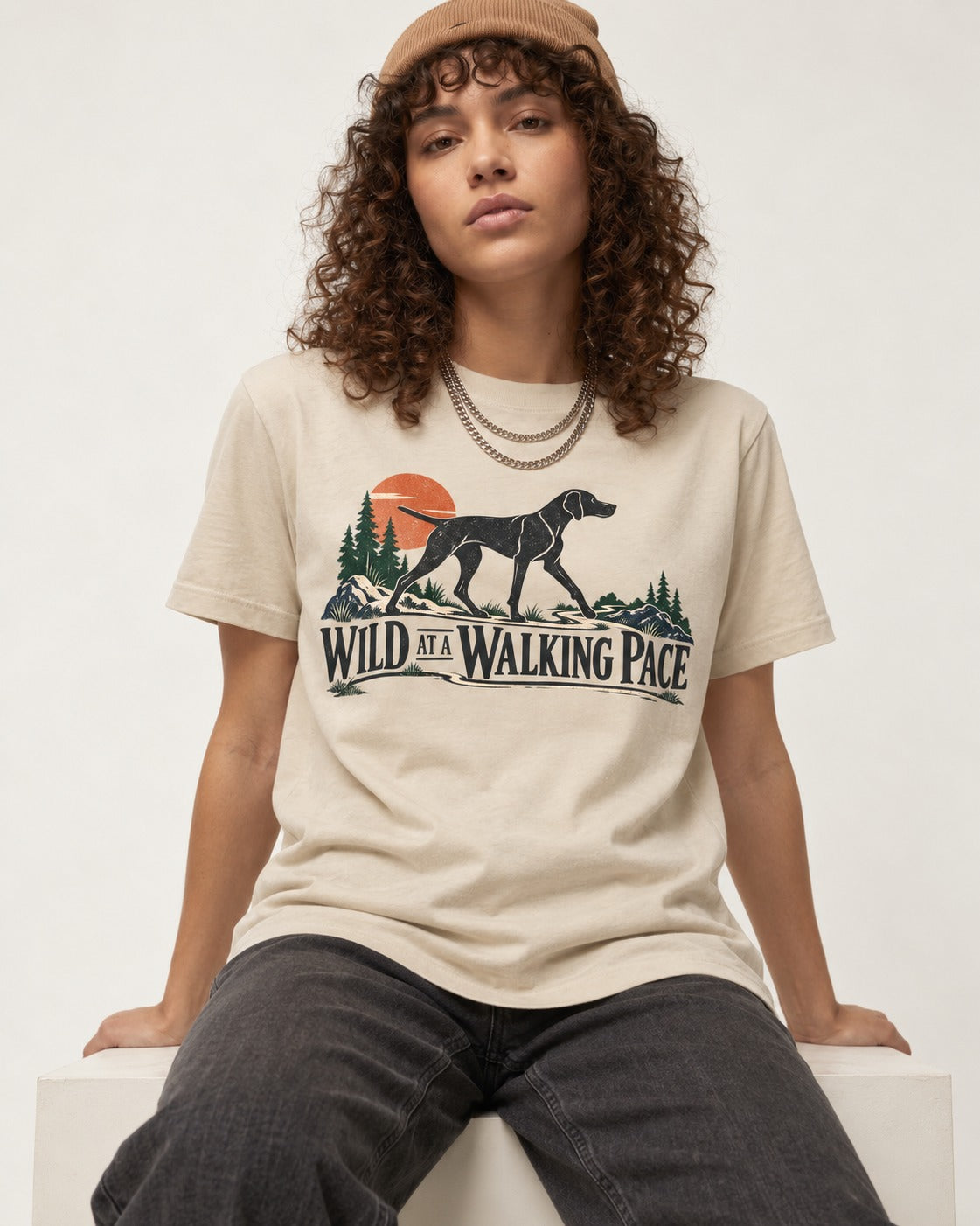 Wild at a Walk German Shorthaired Pointer T-Shirt in Sand, worn by a seated model