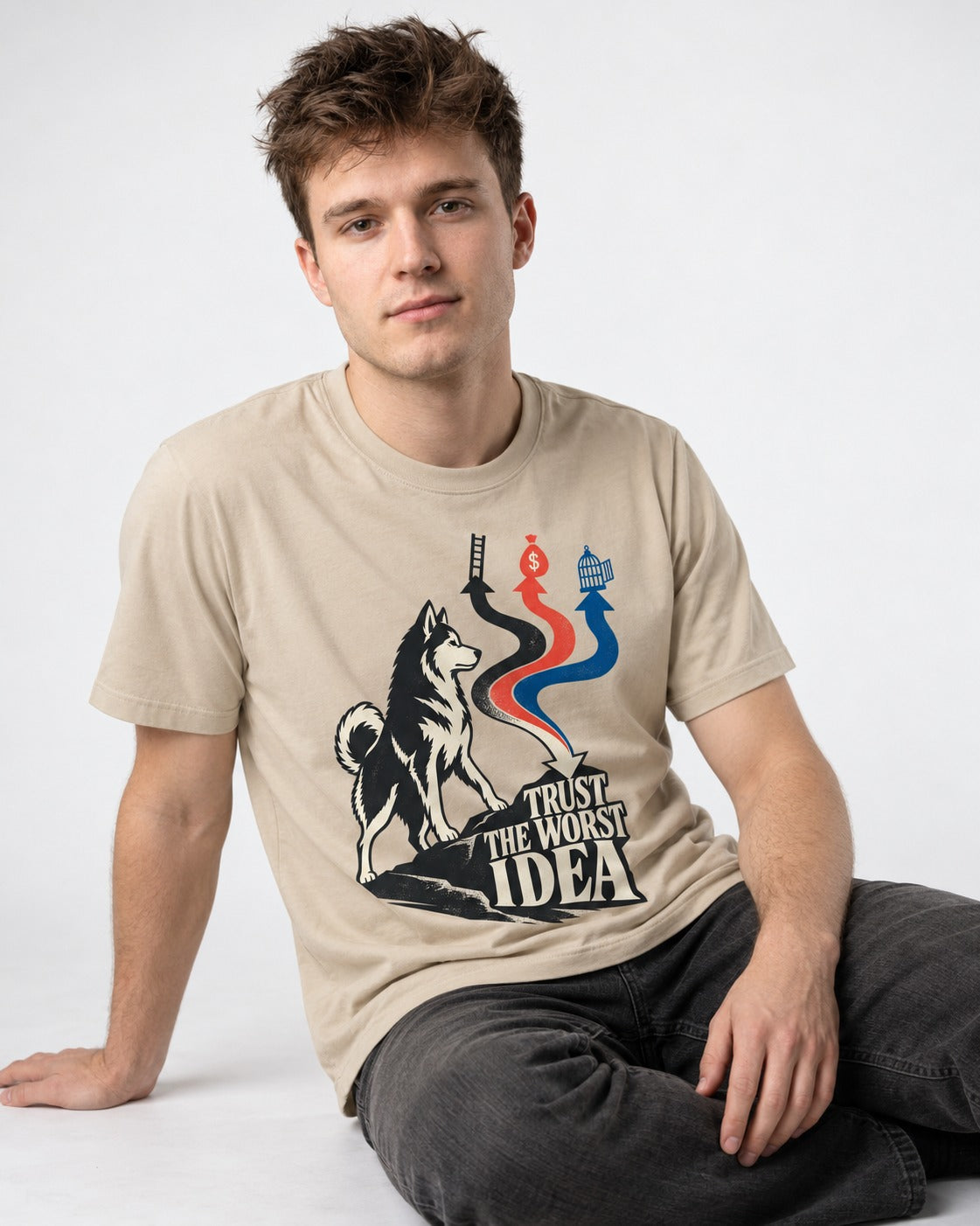Trust the Worst Husky Idea T-Shirt in Sand, worn by a seated model