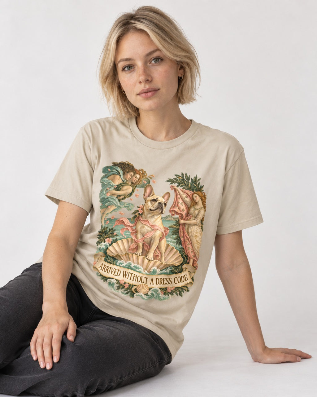 Frenchie Without a Dress Code T-Shirt in Sand, worn by a seated model