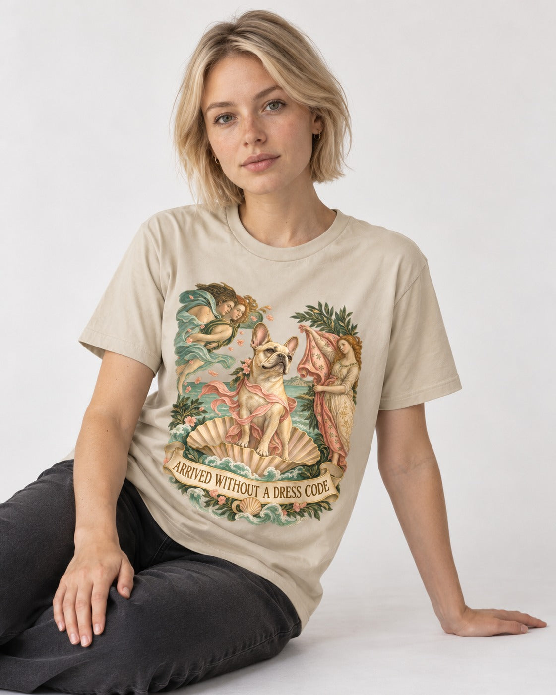 Frenchie Without a Dress Code T-Shirt in Sand, worn by a seated model