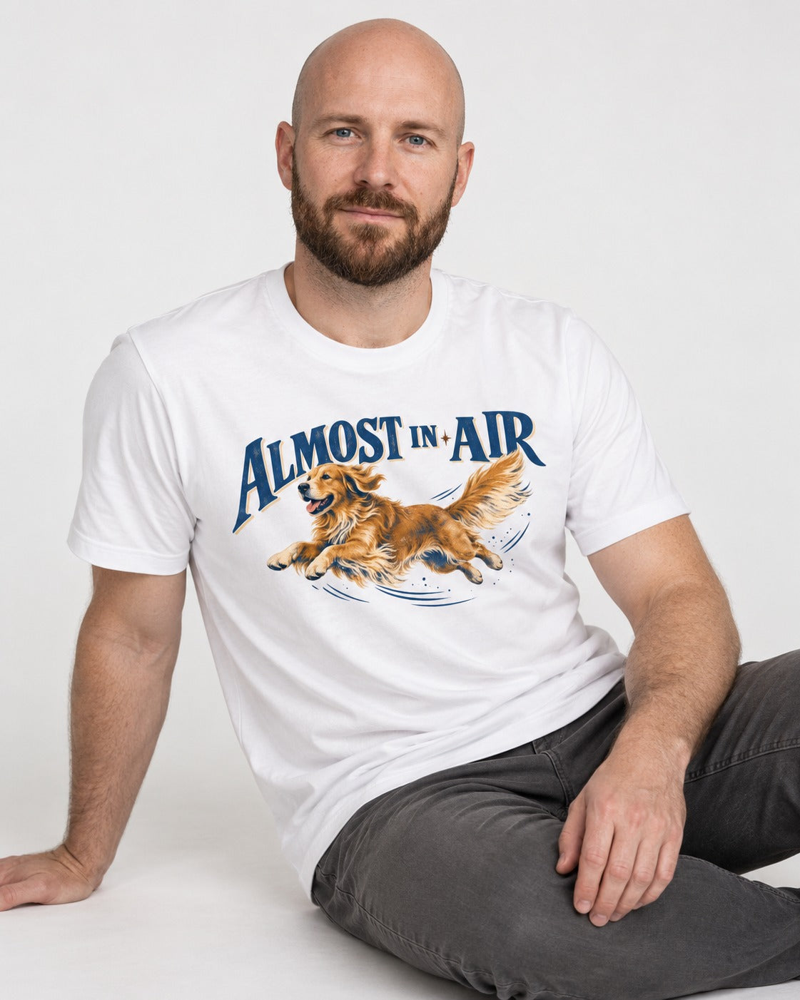Golden Retriever Almost in Air Flying Graphic T-Shirt in White, worn by a seated model