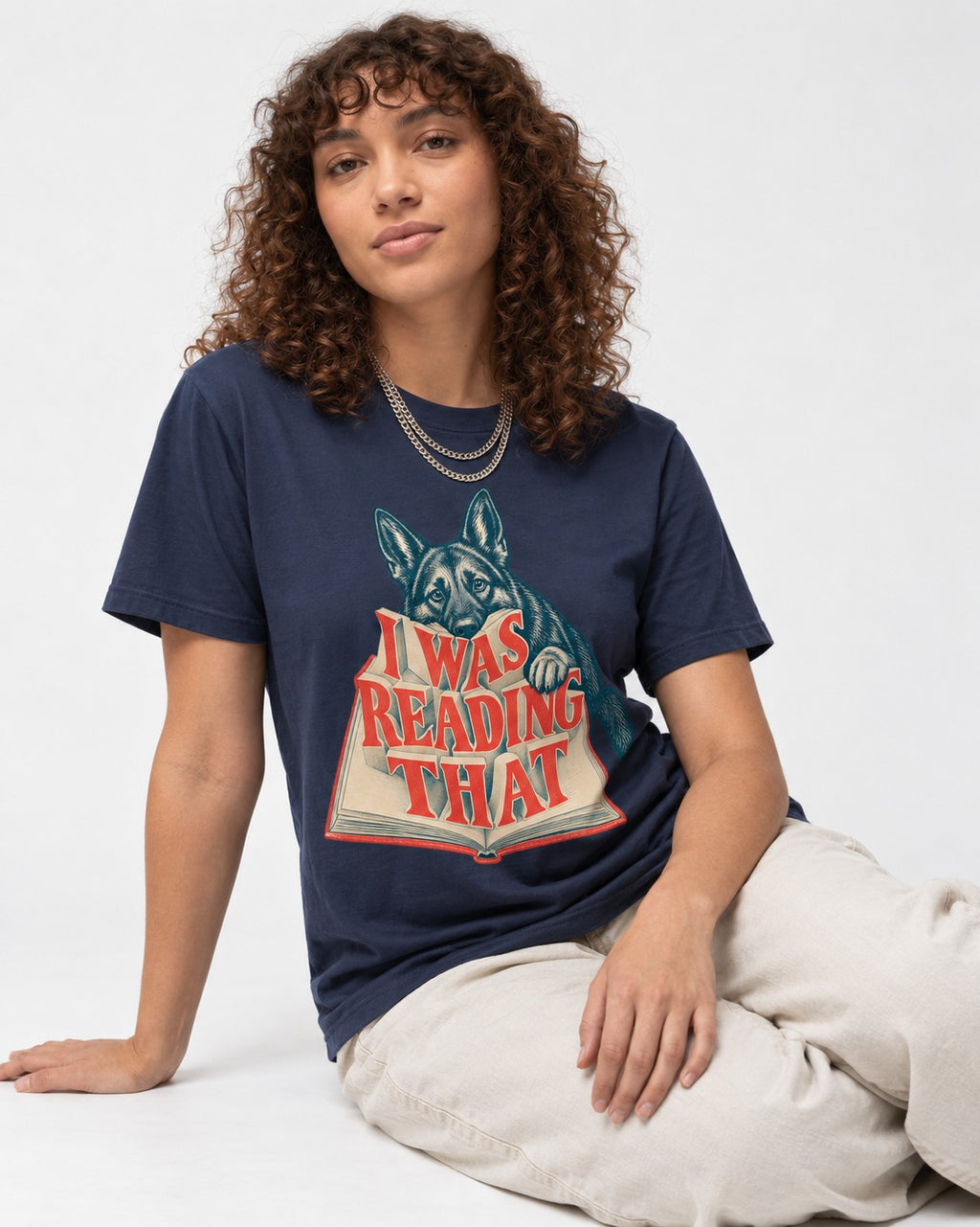 German Shepherd Dog I Was Reading That Open Book Graphic T-Shirt in Navy, worn by a seated model
