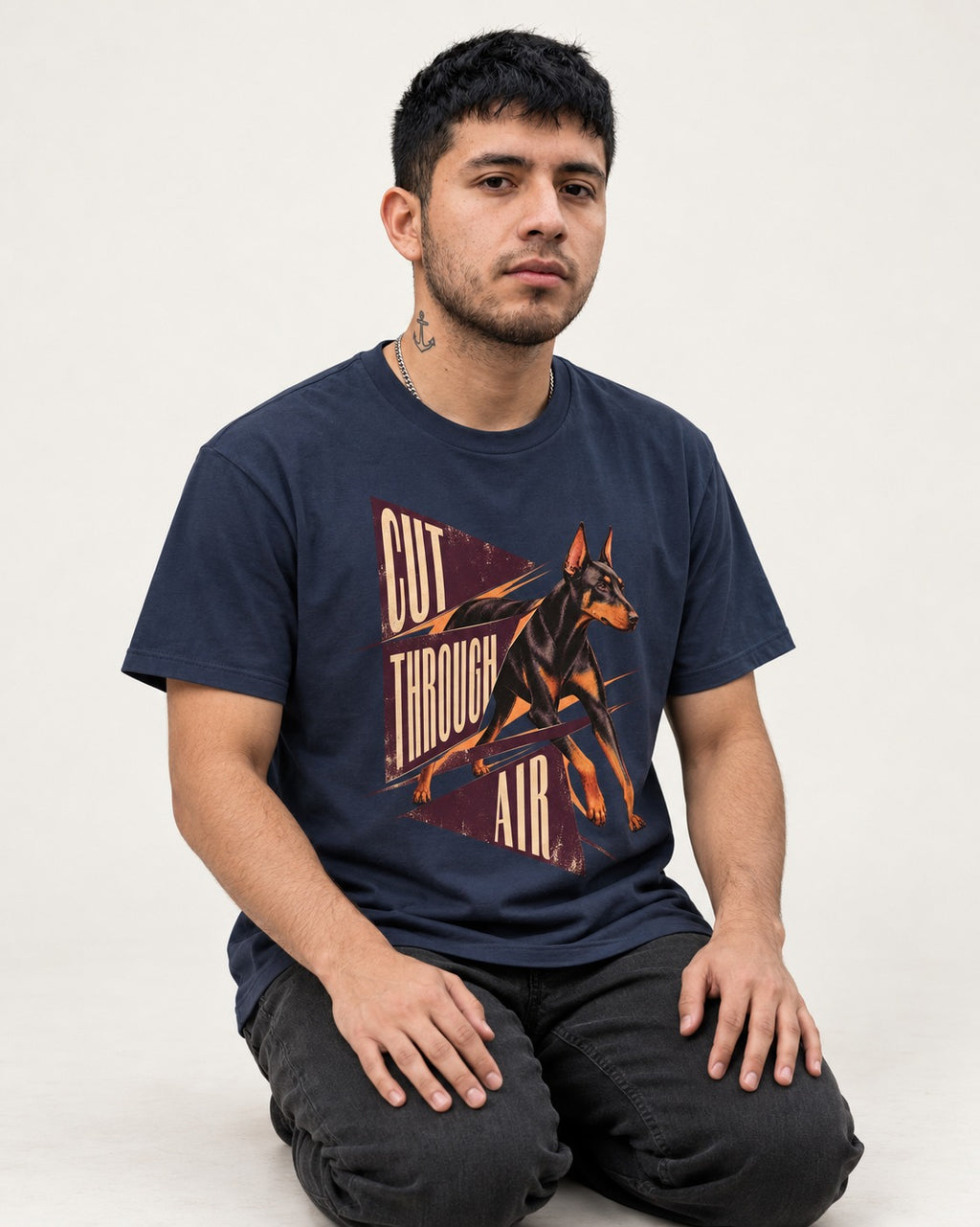 Doberman Cut Through Air Graphic T-Shirt in Navy, worn by a seated model