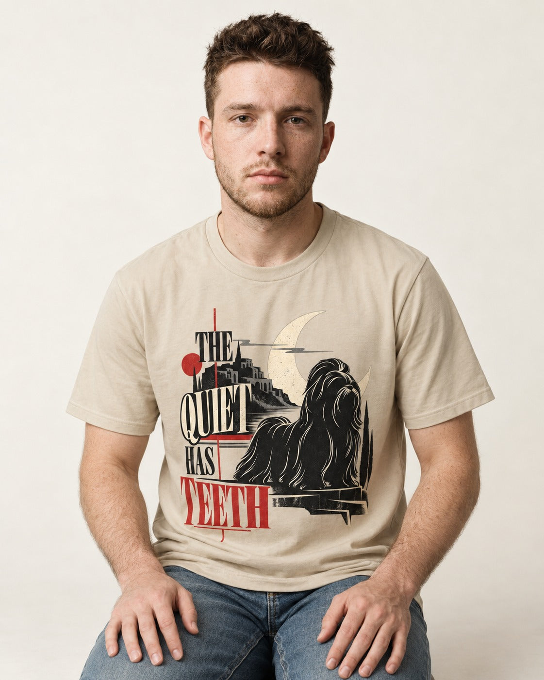 The Quiet Shih Tzu Has Teeth T-Shirt in Sand, worn by a seated model