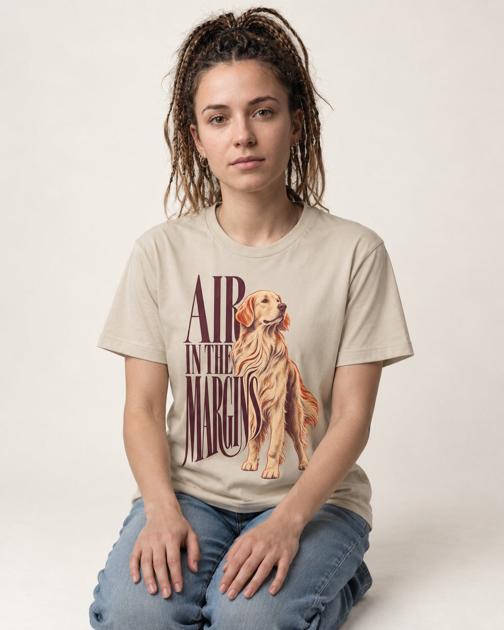 Golden Retriever In the Margins T-Shirt in Sand, worn by a seated model