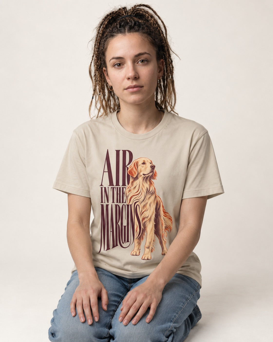 Golden Retriever In the Margins T-Shirt in Sand, worn by a seated model