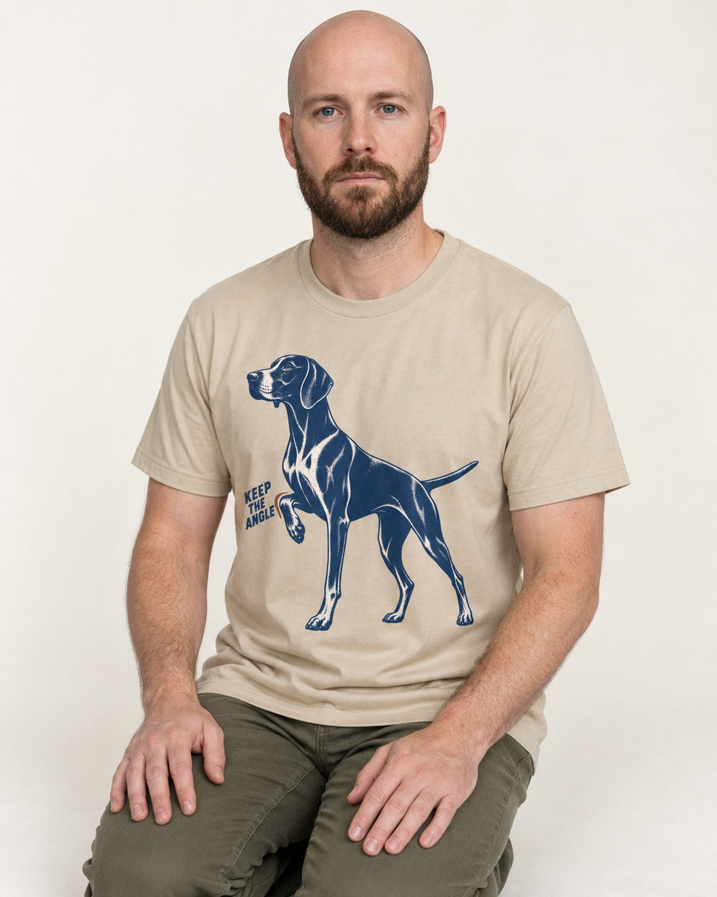 Keep the Angle German Shorthaired Pointer T-Shirt in Sand, worn by a seated model