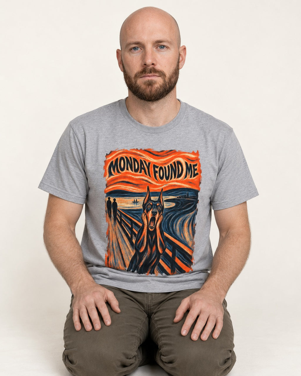 Doberman Monday Found Me Scream Graphic T-Shirt in Sport Grey, worn by a seated model