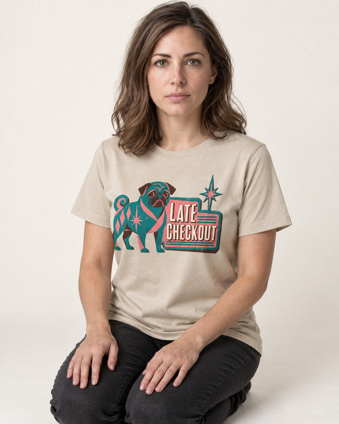 Pug's Late Checkout T-Shirt in Sand, worn by a seated model