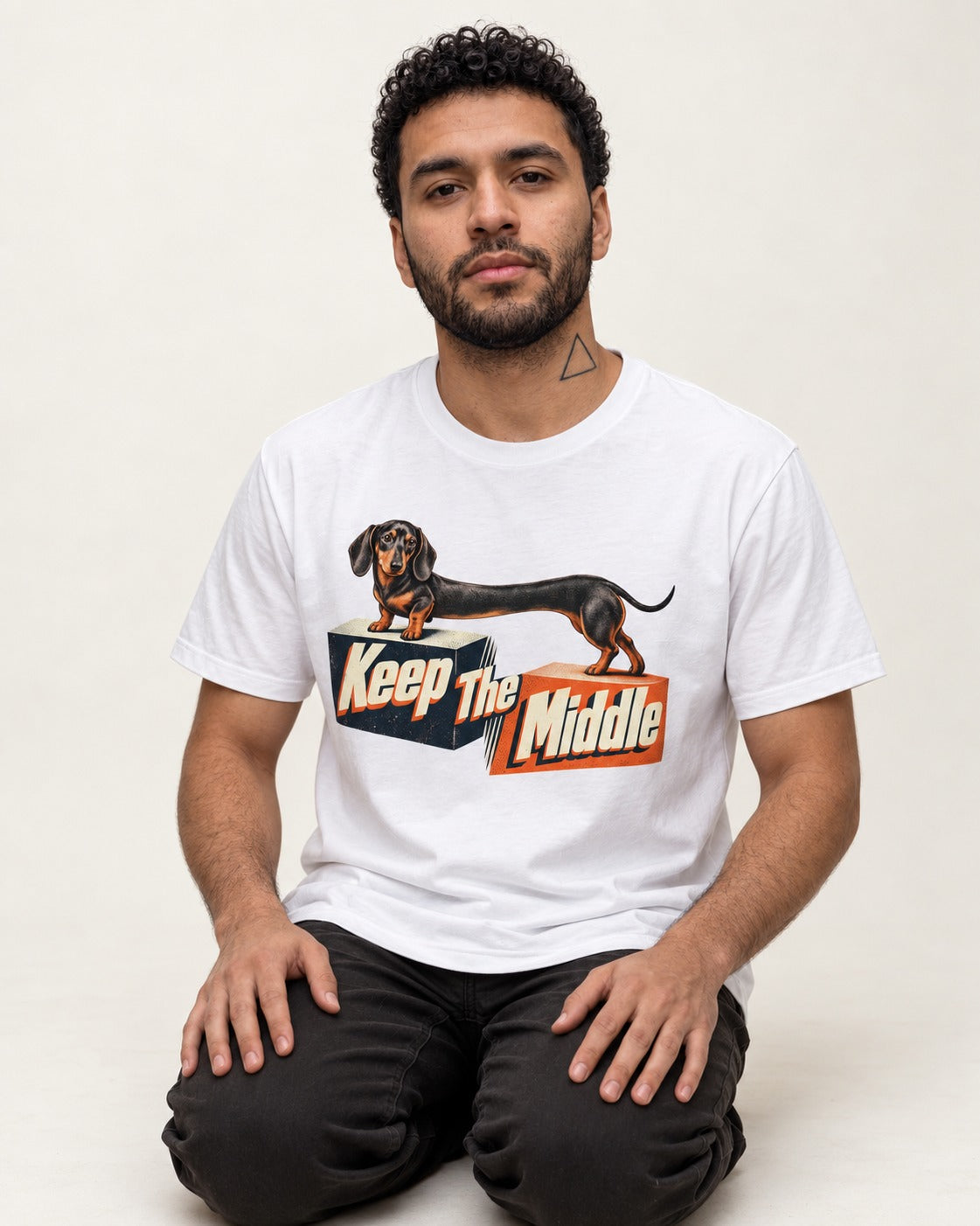 Dachshund Keep The Middle Block Bridge Graphic T-Shirt in White, worn by a seated model