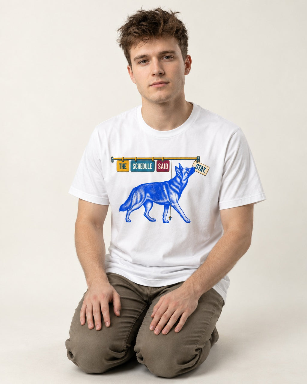 German Shepherd Dog The Schedule Said Stay Graphic T-Shirt in White, worn by a seated model