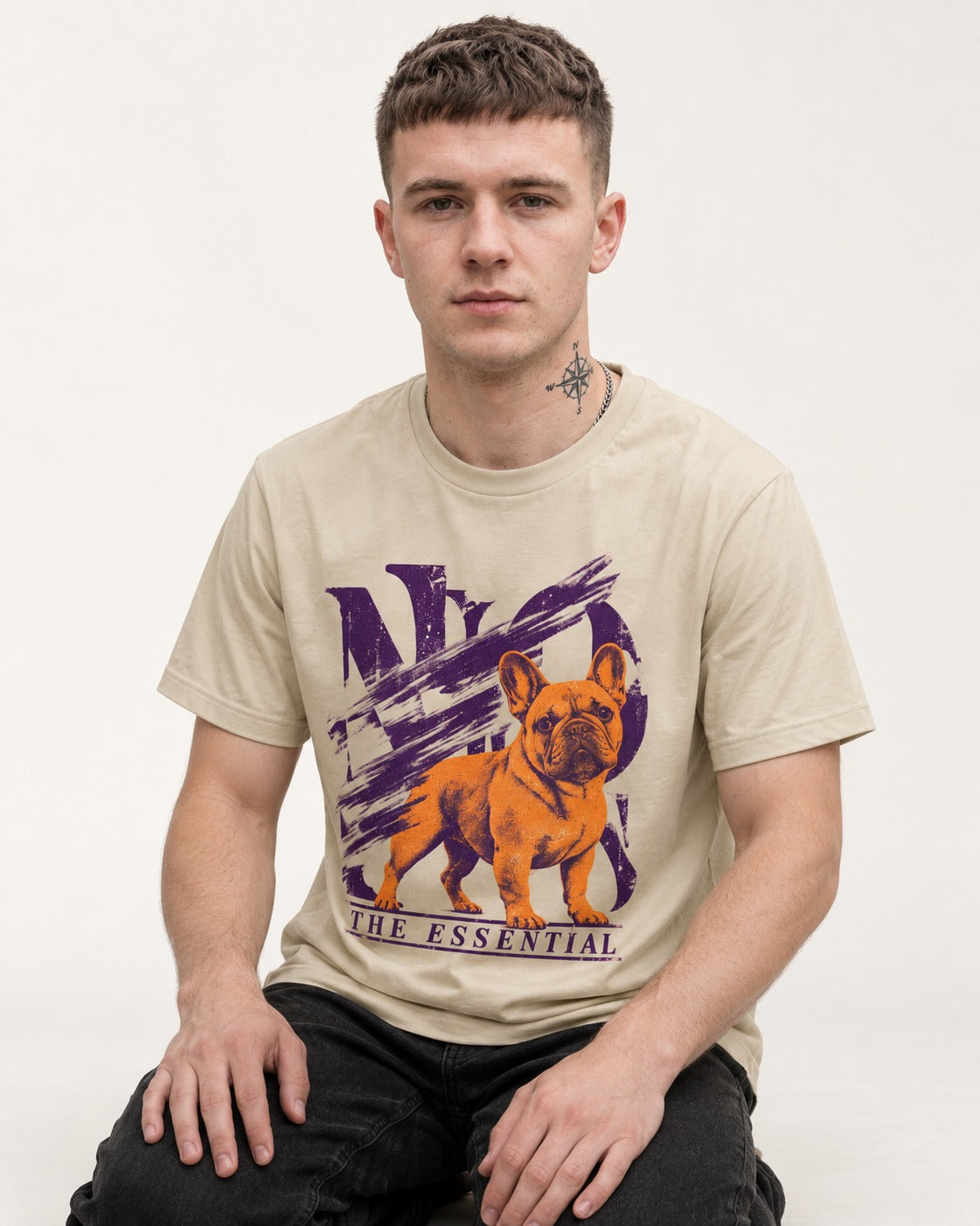 The Essential Frenchie T-Shirt in Sand, worn by a seated model
