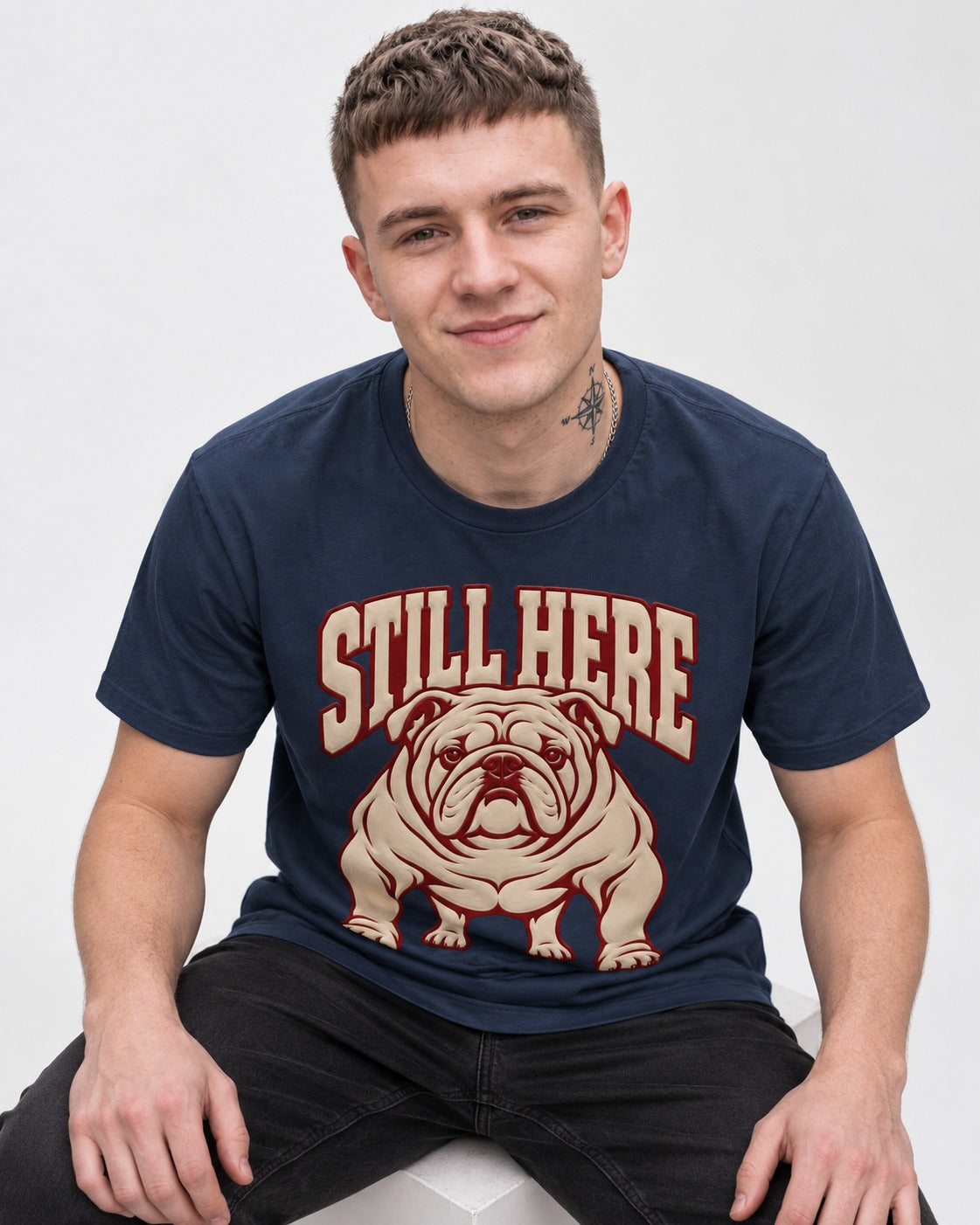 English Bulldog Still Here Collegiate Graphic T-Shirt in Navy, worn by a seated model