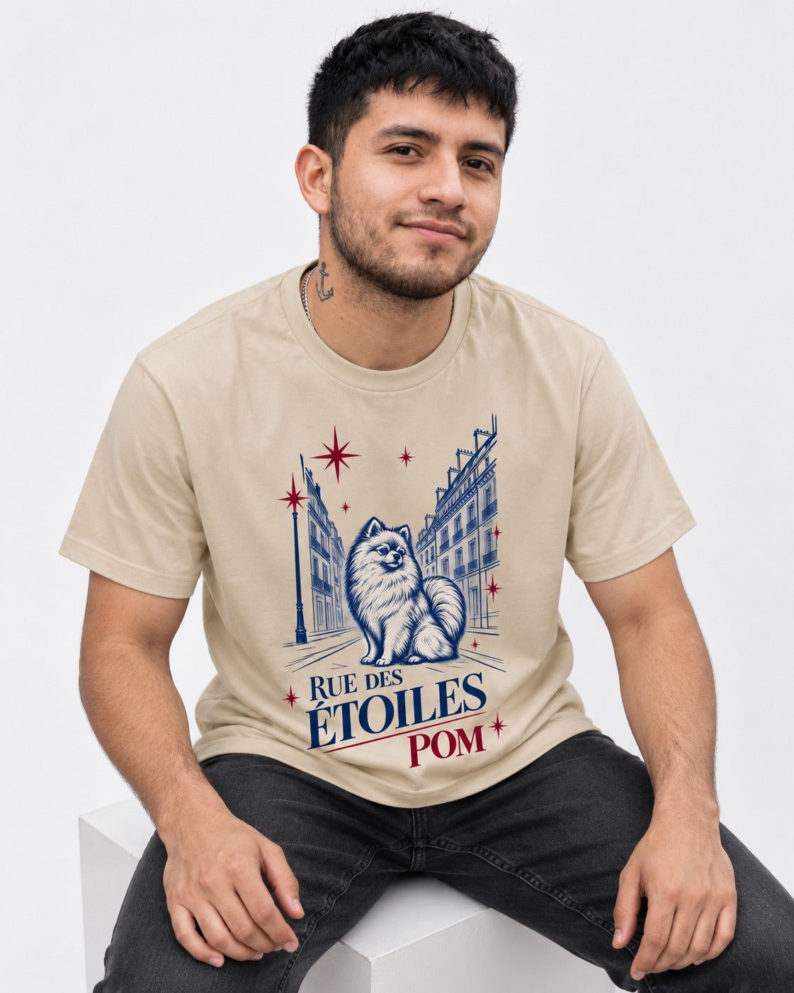 Pomeranian Among the Stars T-Shirt in Sand, worn by a seated model