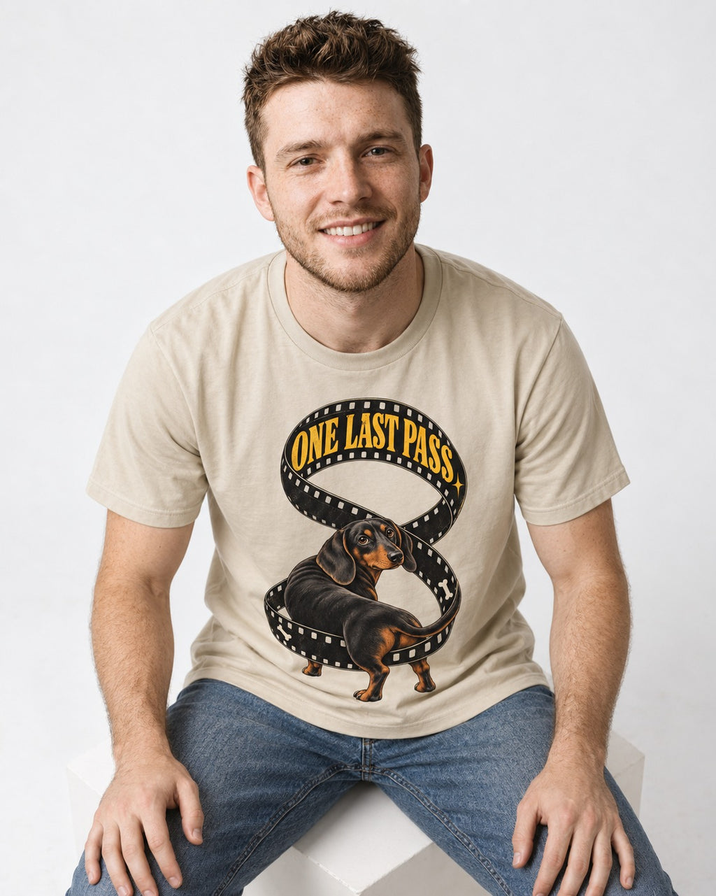 Dachshund's One Last Pass T-Shirt in Sand, worn by a seated model