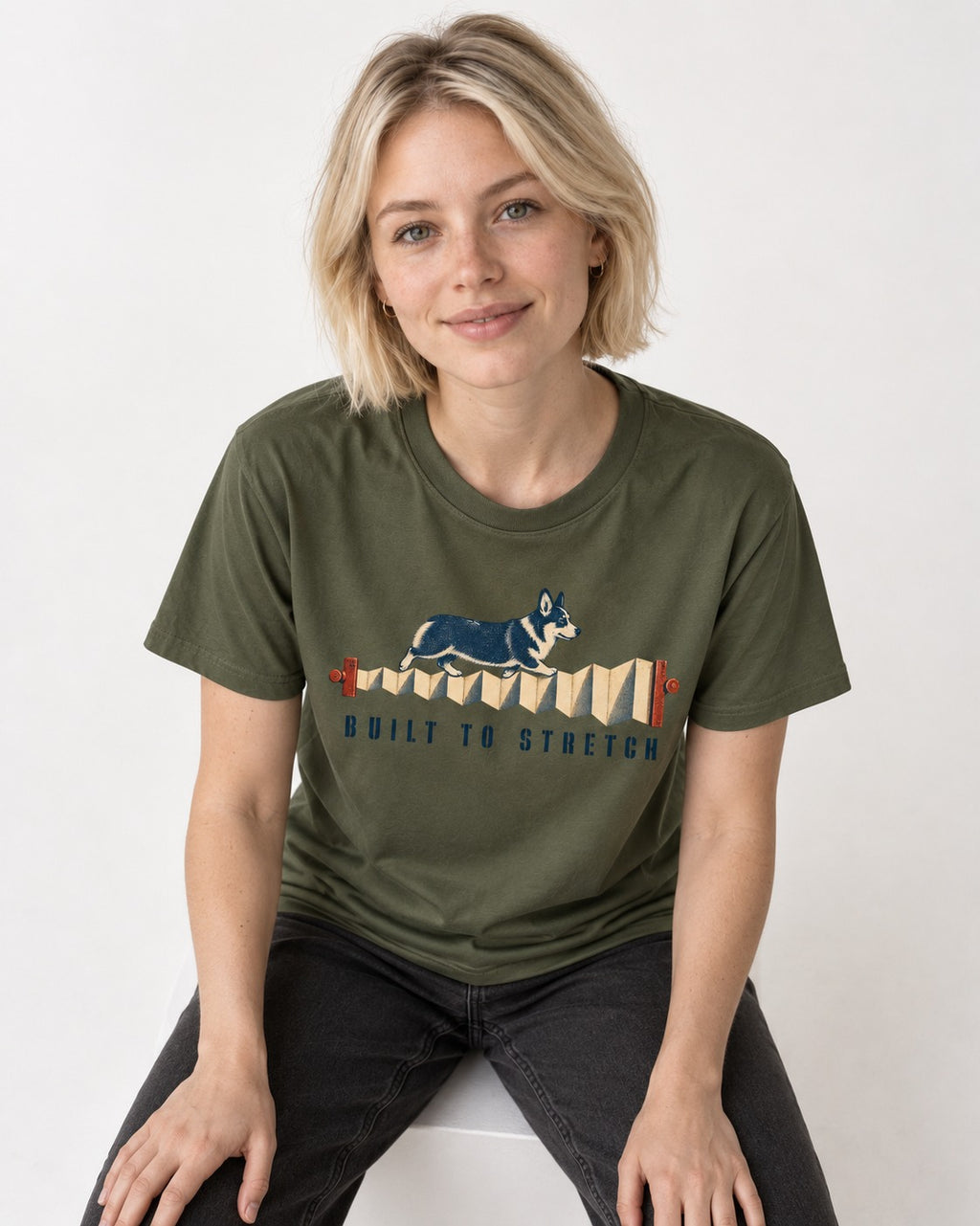 Corgi Built to Stretch Accordion Graphic T-Shirt in Heather Military Green, worn by a seated model