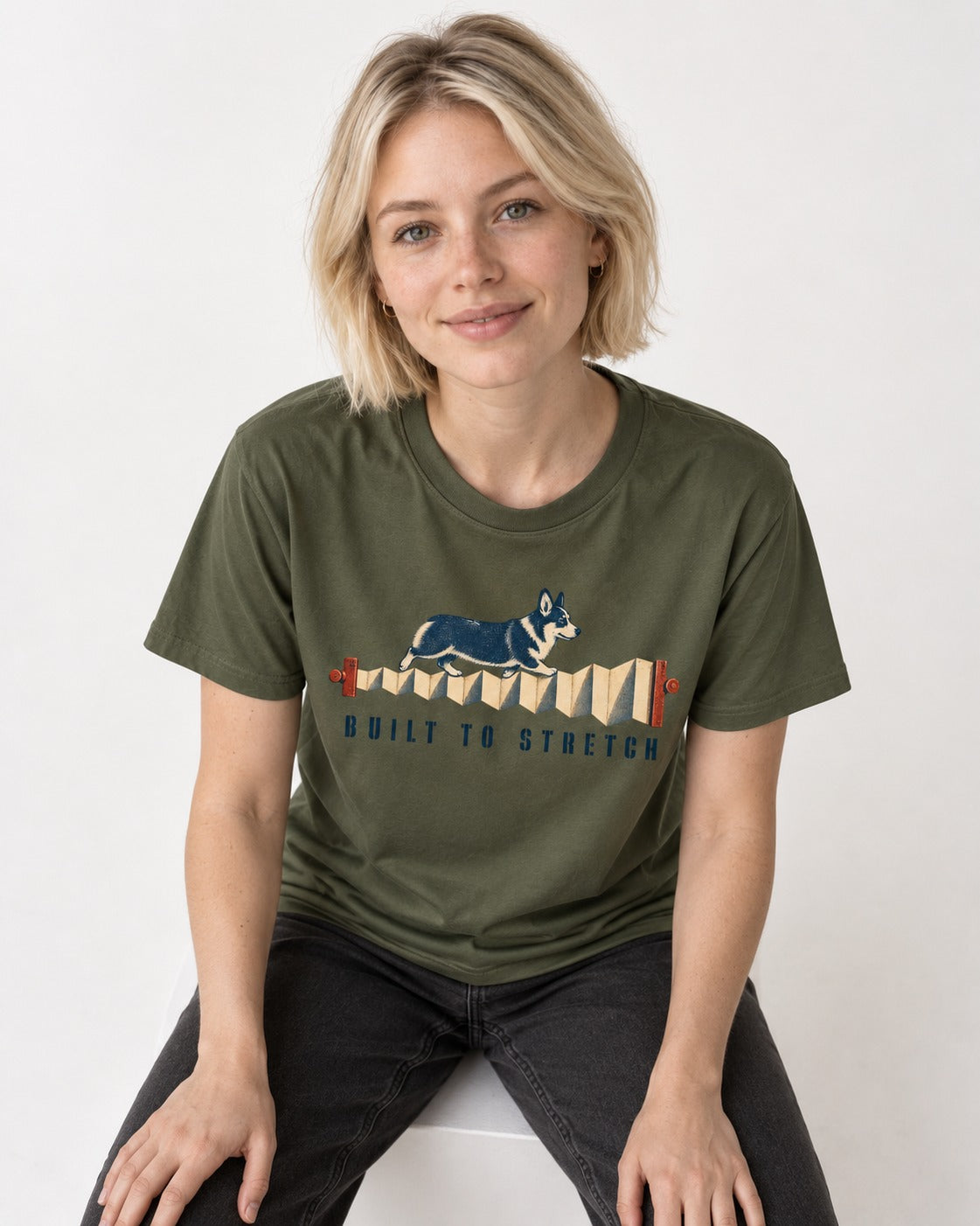 Corgi Built to Stretch Accordion Graphic T-Shirt in Heather Military Green, worn by a seated model