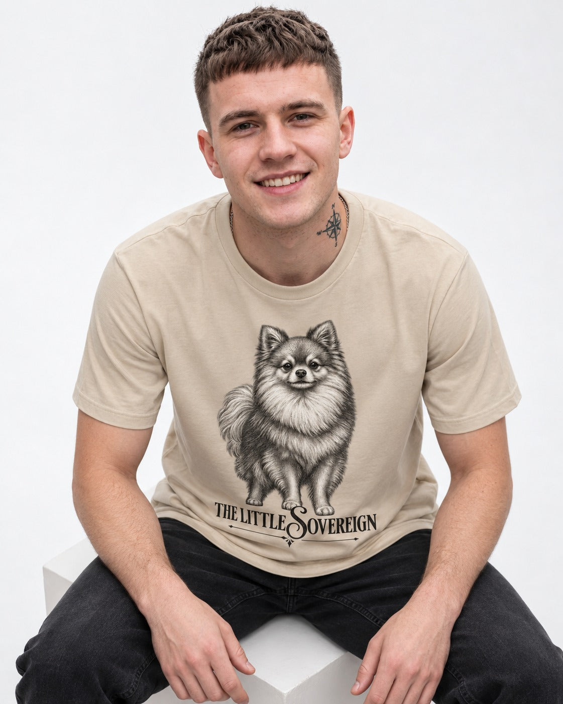 The Little Sovereign Pomeranian T-Shirt in Sand, worn by a seated model