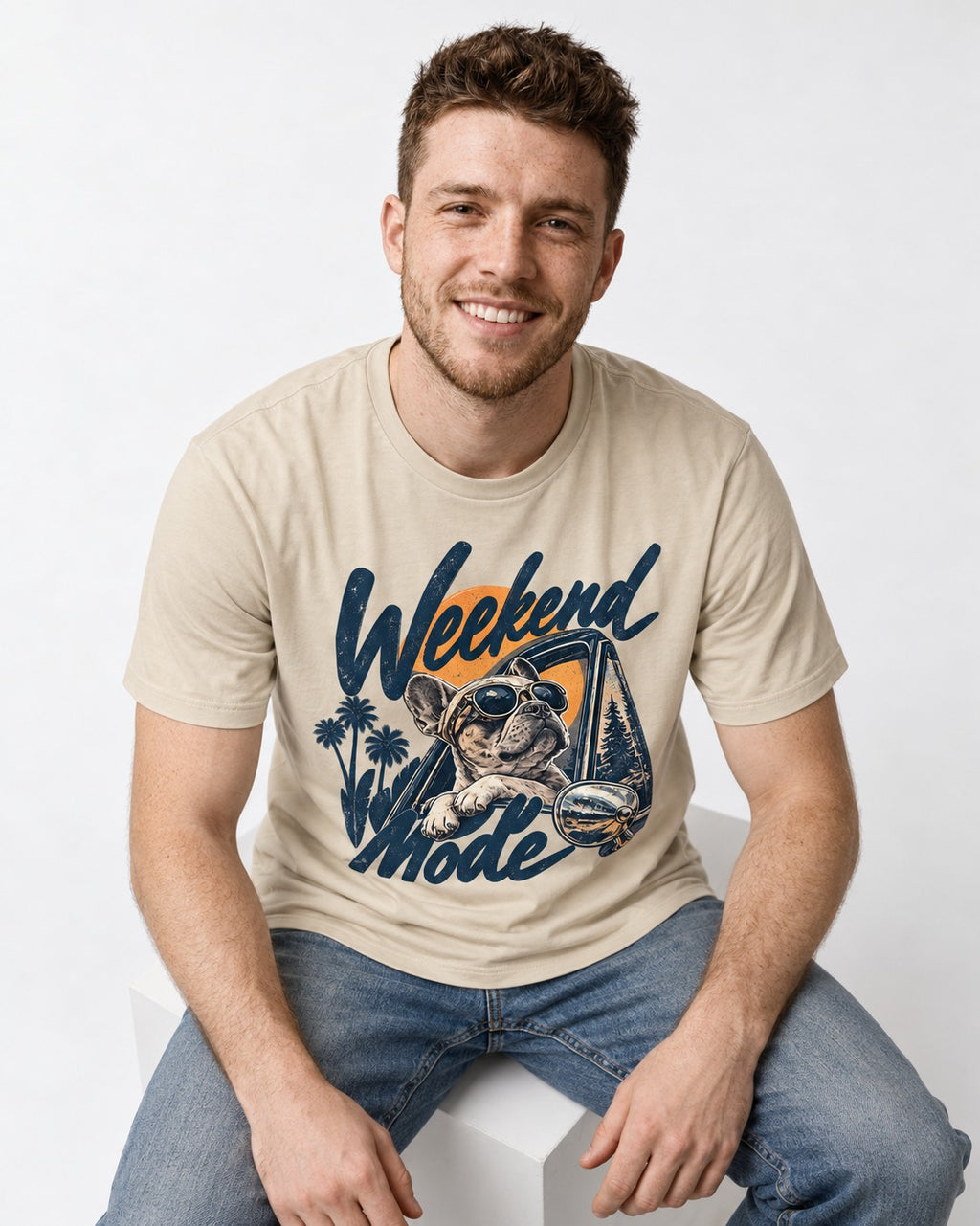 Frenchie Weekend Mode Road Trip Graphic T-Shirt in Sand, worn by a seated model