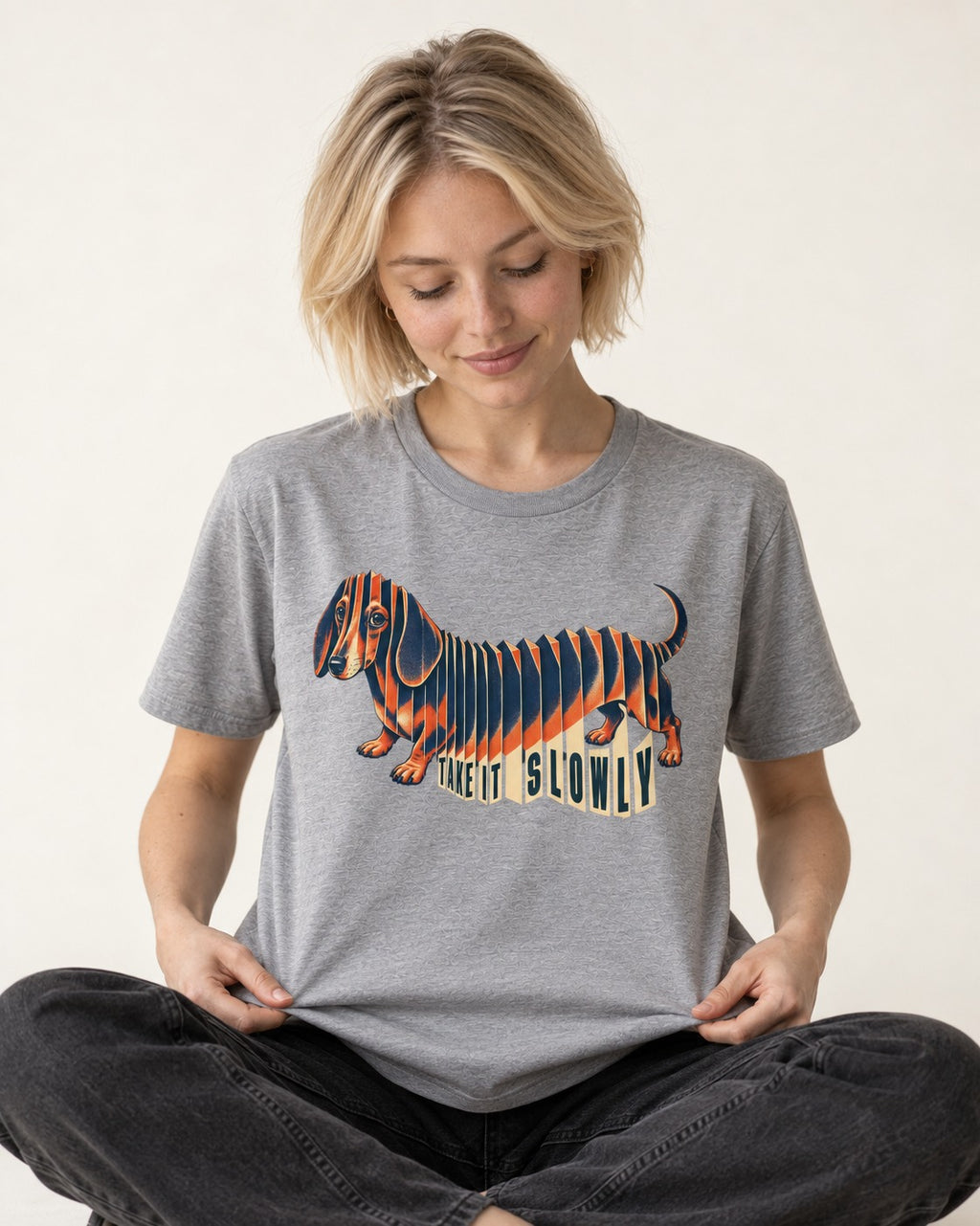 Take It Slowly Dachshund T-Shirt in Sport Grey, worn by a seated model